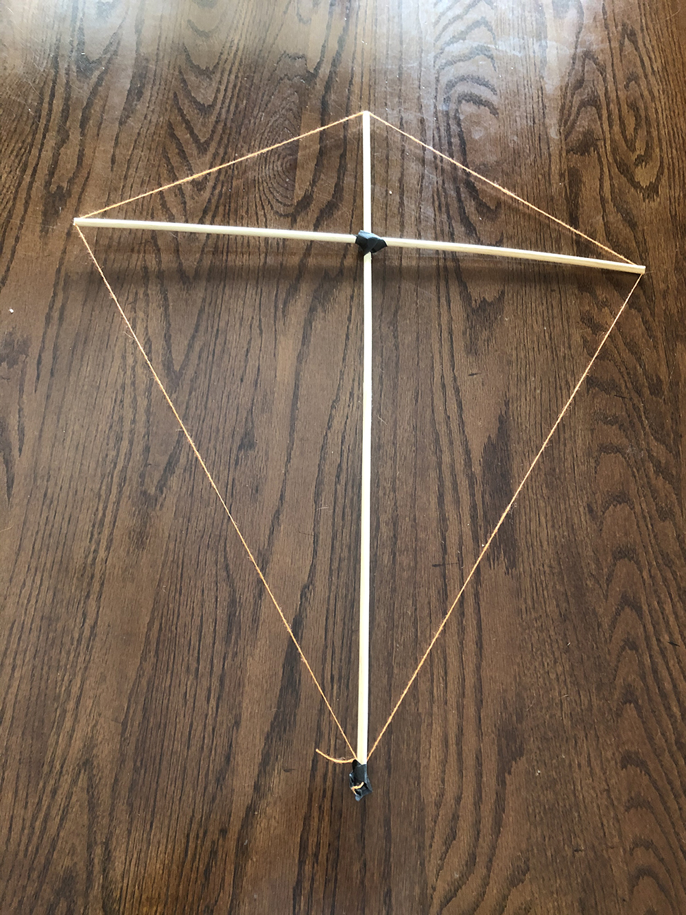 Dowels with string wrapped around the perimeter forming a classic diamond kite shape