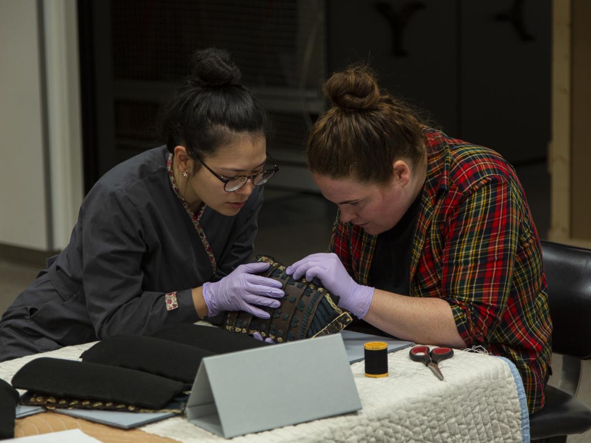 Stacey Kelly and Adelaide Ryder work together to safely attach Ethafoam supports to each panel on the Samurai Armor.