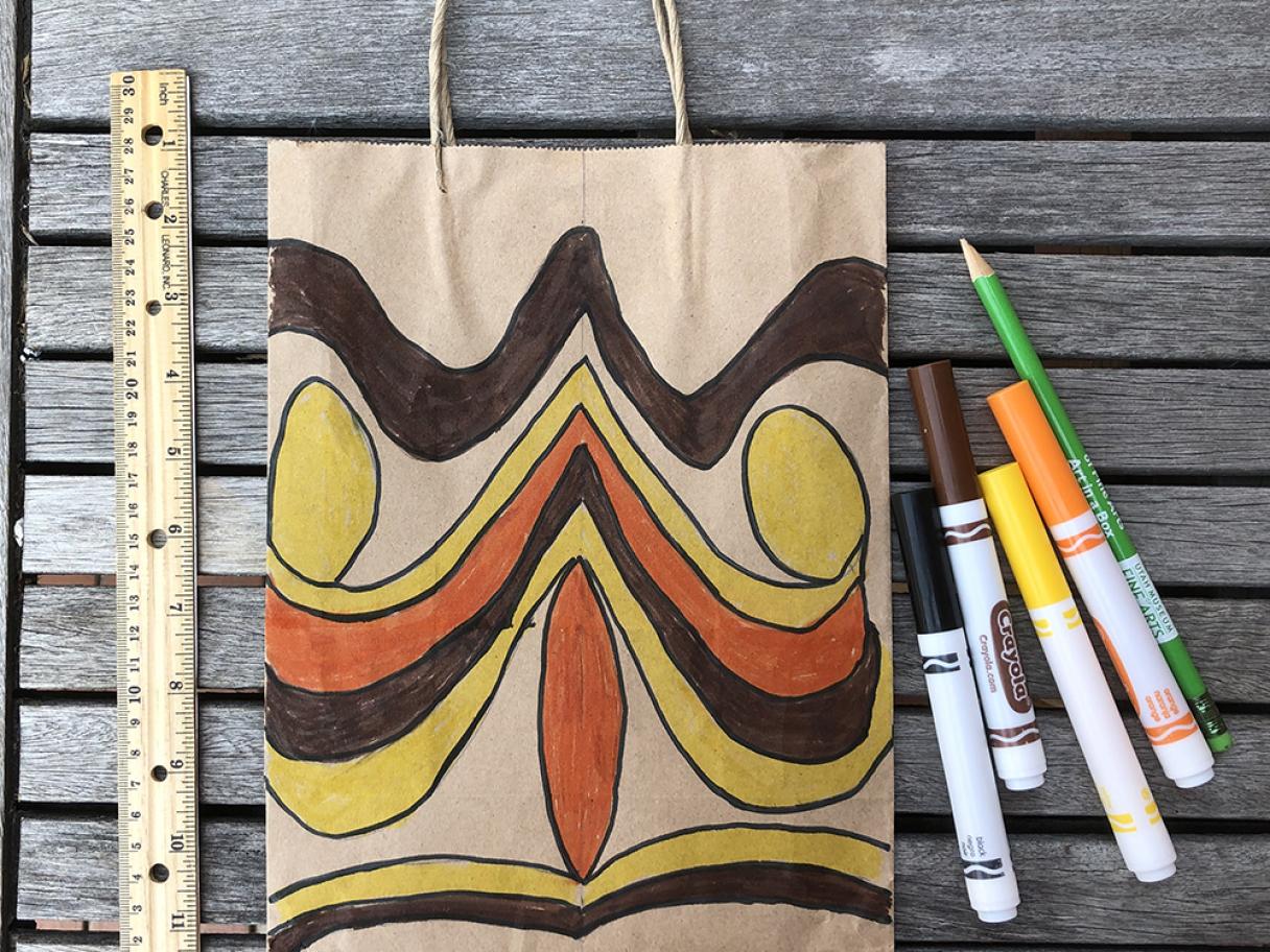a paper bag with an abstract face made of yellow, brown and orange