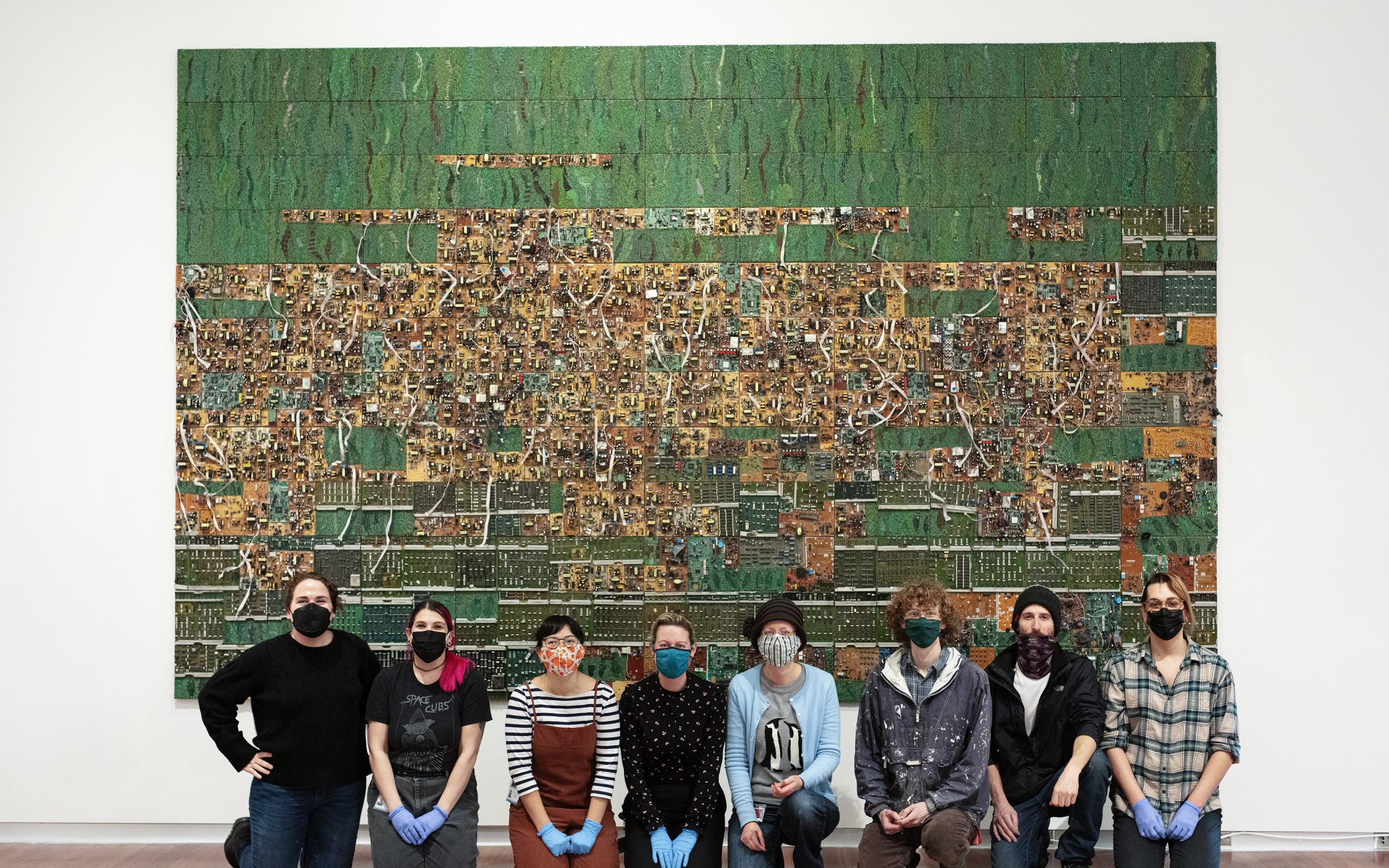 The UMFA collections and prepatory team proudly sits in front of "Tightrope" by Elias Sime. This wall sculpture is made up of 131 panels and took a week to install. 