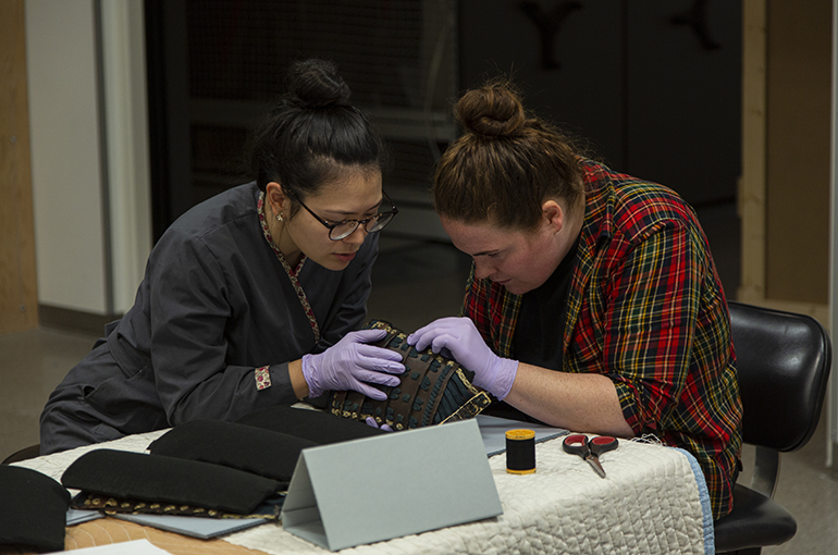 Beyond the Divide conservation, armor sewing UMFA conservato Stacey Kelly and collections photographer Adelaide Ryder sew Samuri Armor to its mount