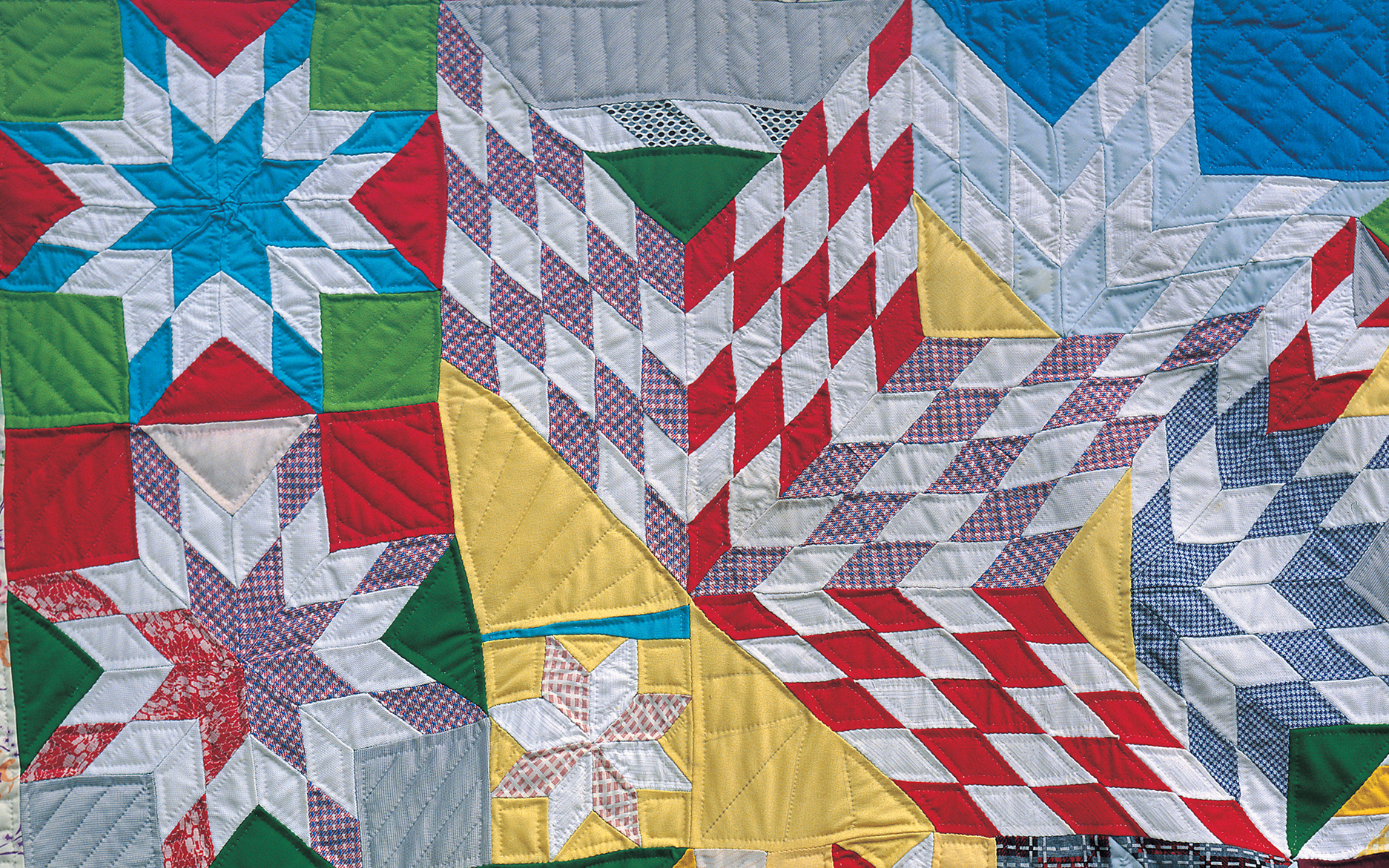 quilt made of a star pattern in red, yellow, purple and white