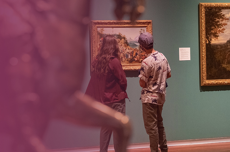 two people look at a painting in the European Gallery at the UMFA