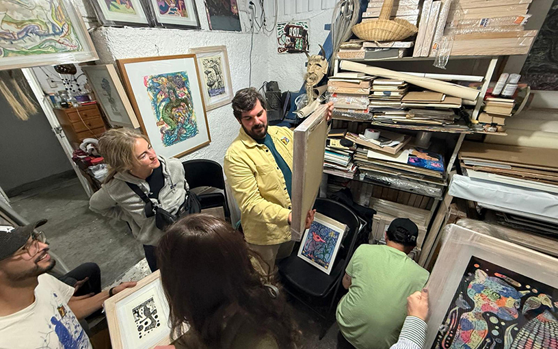 Peter Hay looking at art in a studio.