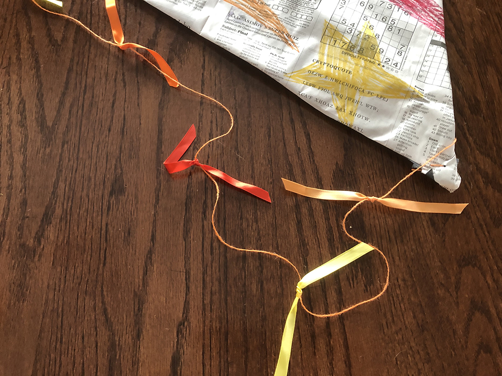 Bottom half of the kite with a tail of yellow and red ribbon bows