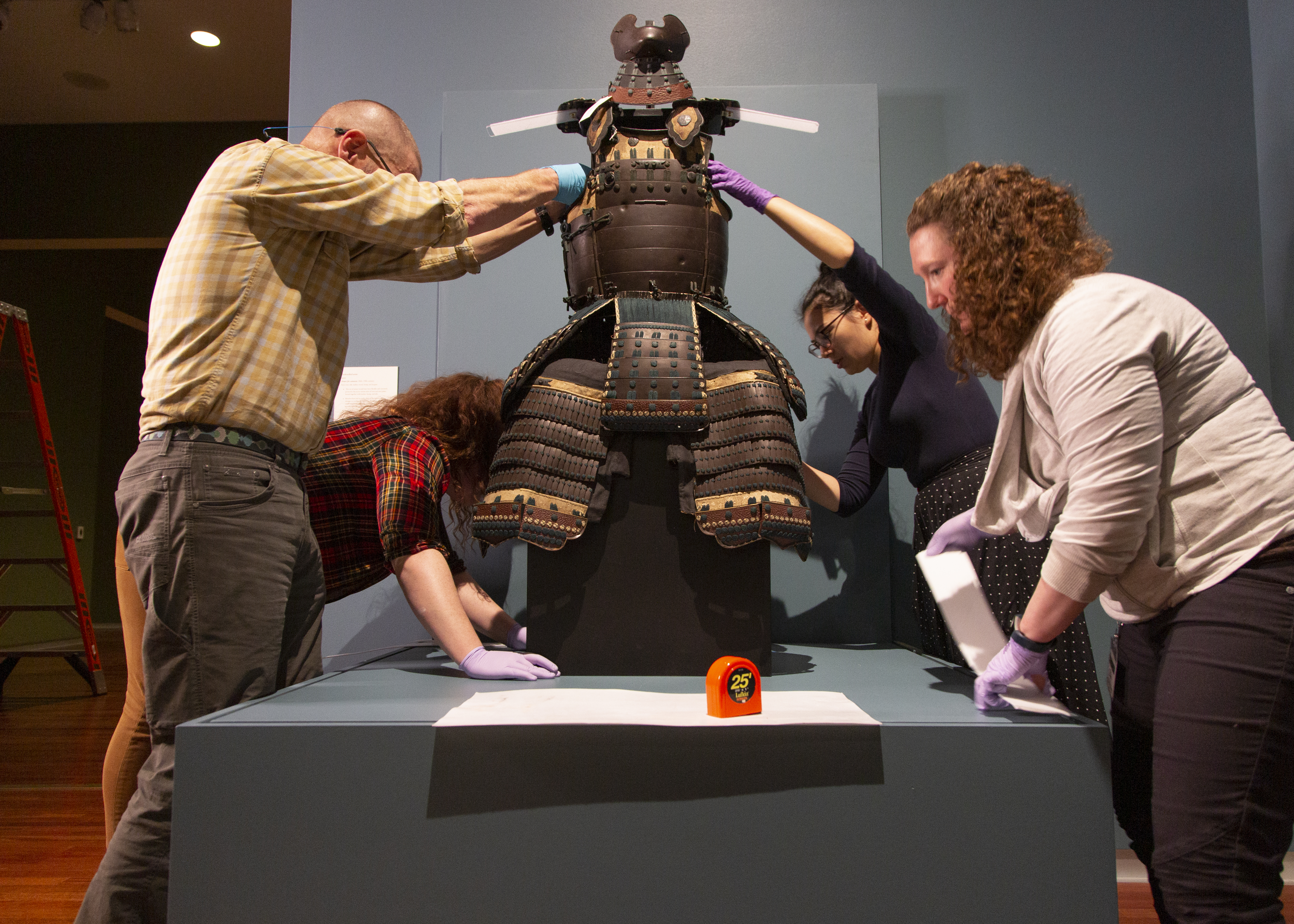 Preparing the Samurai Armor for exhibition required the help of more than 7 people. Here you see Collection’s staff sewing backing, preparing foam, and measuring armature.  