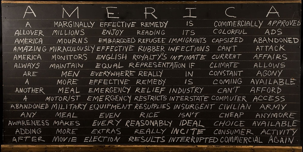 A blackboard with AMERICA written across the top in white chalk acrostic sentences of AMERICA fill the board underneath