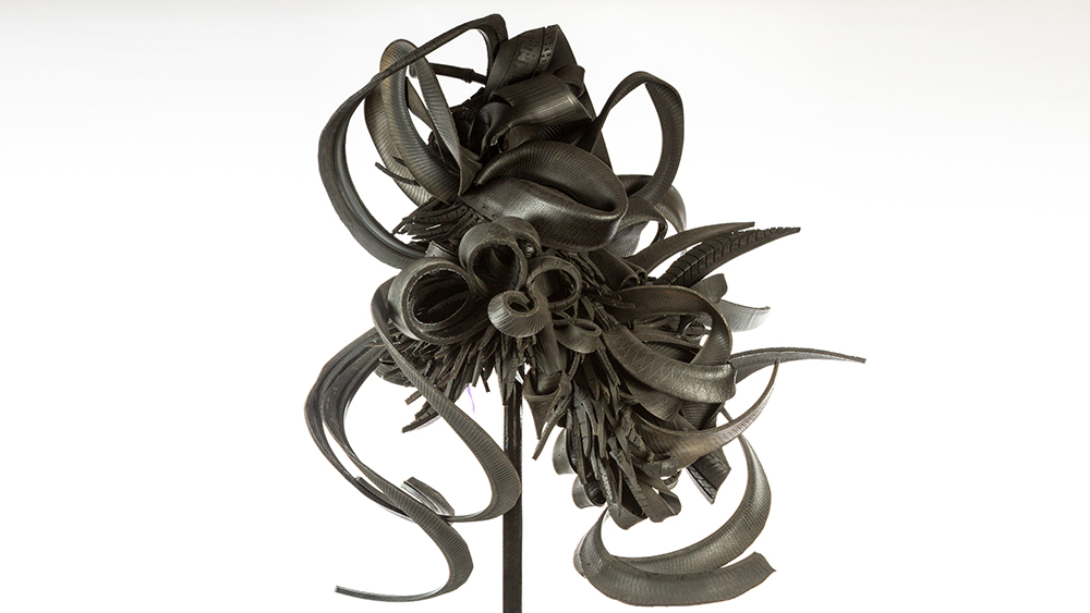 Discarded Memories by Chakaia Booker, a black, swirling, knotted sculpture made of cut and sliced tires, sculpture is about 5 feet tall by 5 feet wide 