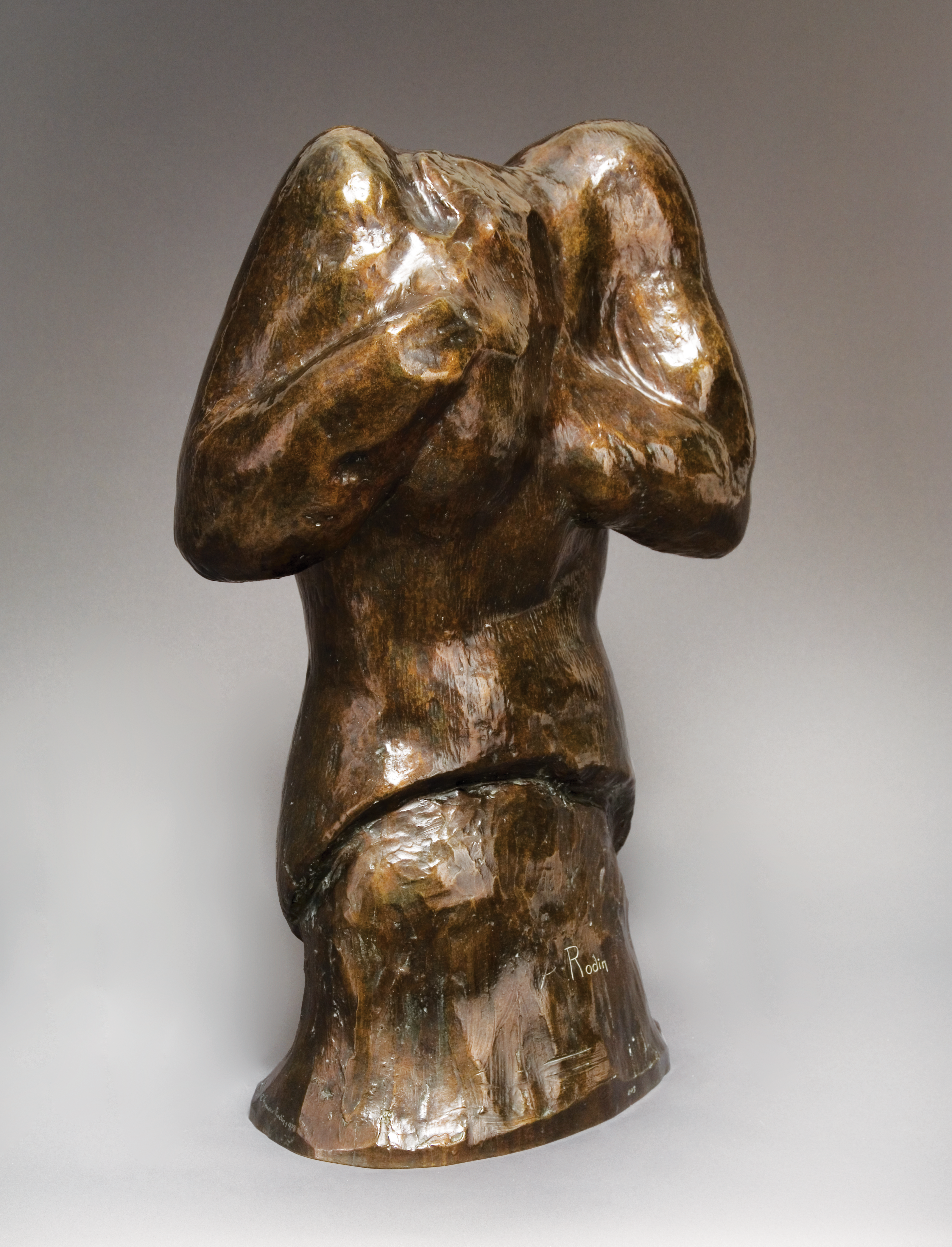 A bronze statue of a figure slouching and holding her head in her hands. The proportions are exaggerated so the figures head is hung so low it melts into her chest.