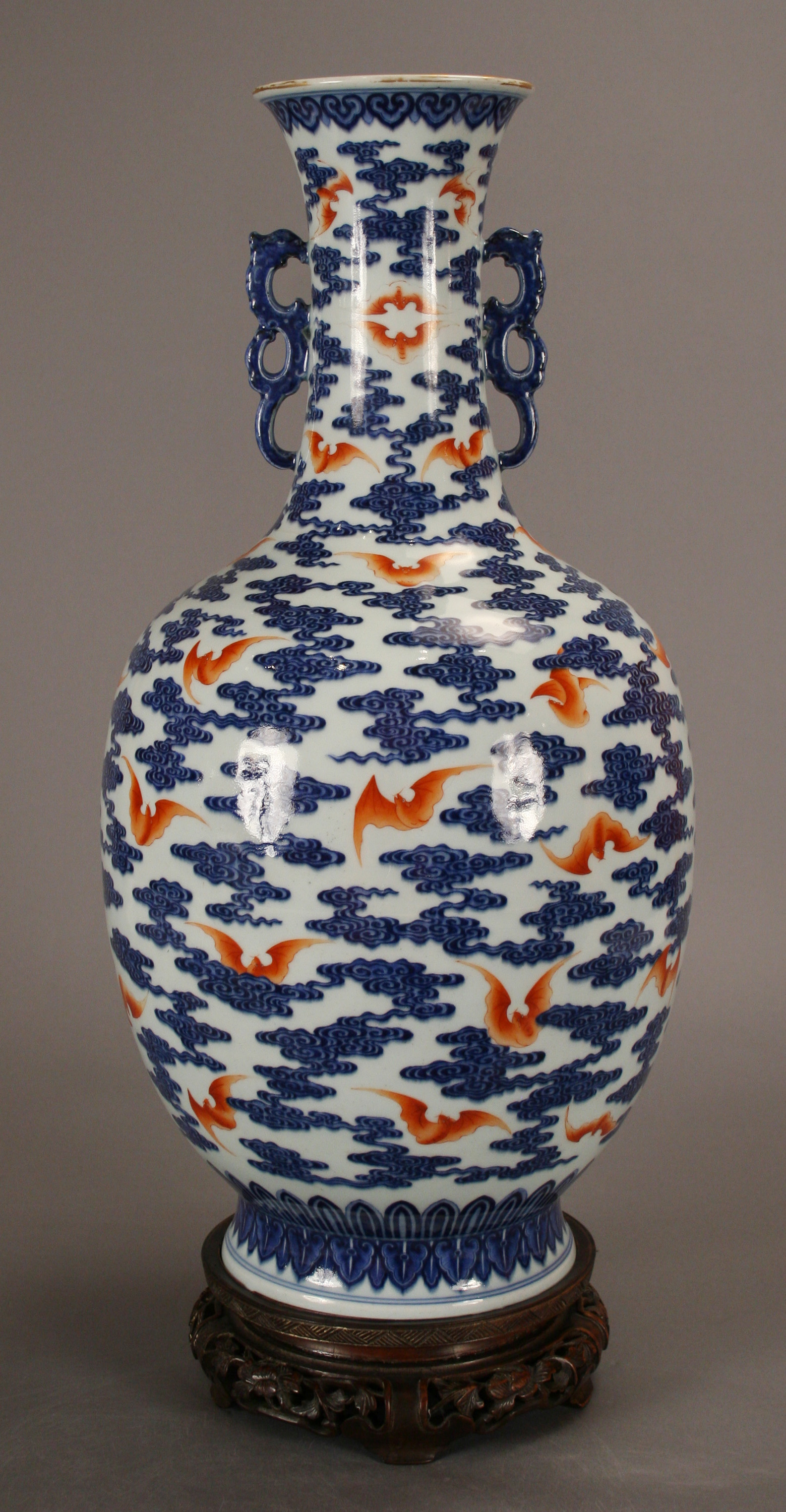 A porcelain vase with blue clouds and orange bats.