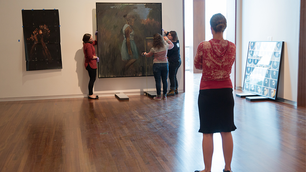 UMFA Senior Curator Whitney Tassie watches the collections department reinstall the Modern and Contemporary Gallery in the summer of 2017