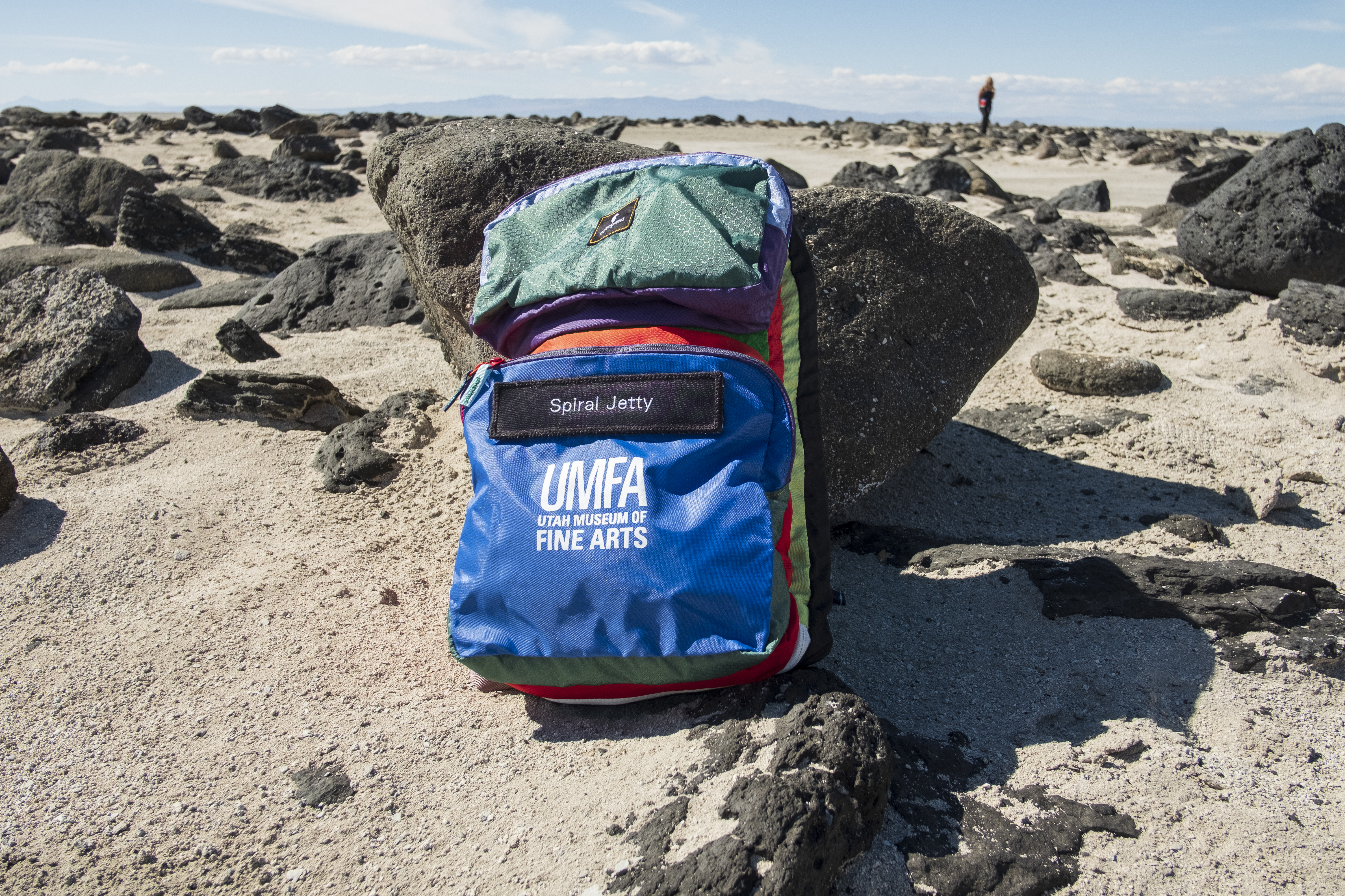 A colorful backpack with the UMFA logo and a label that reads "spiral jetty"