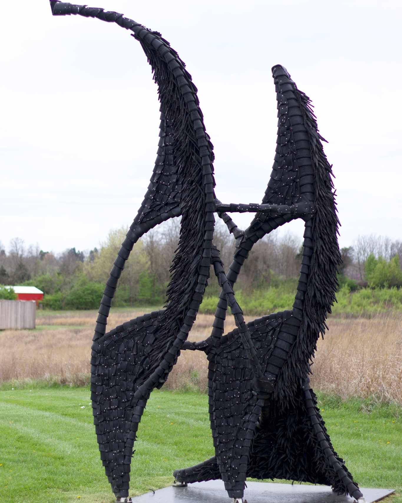 A sculpture made of tires standing in a green field.