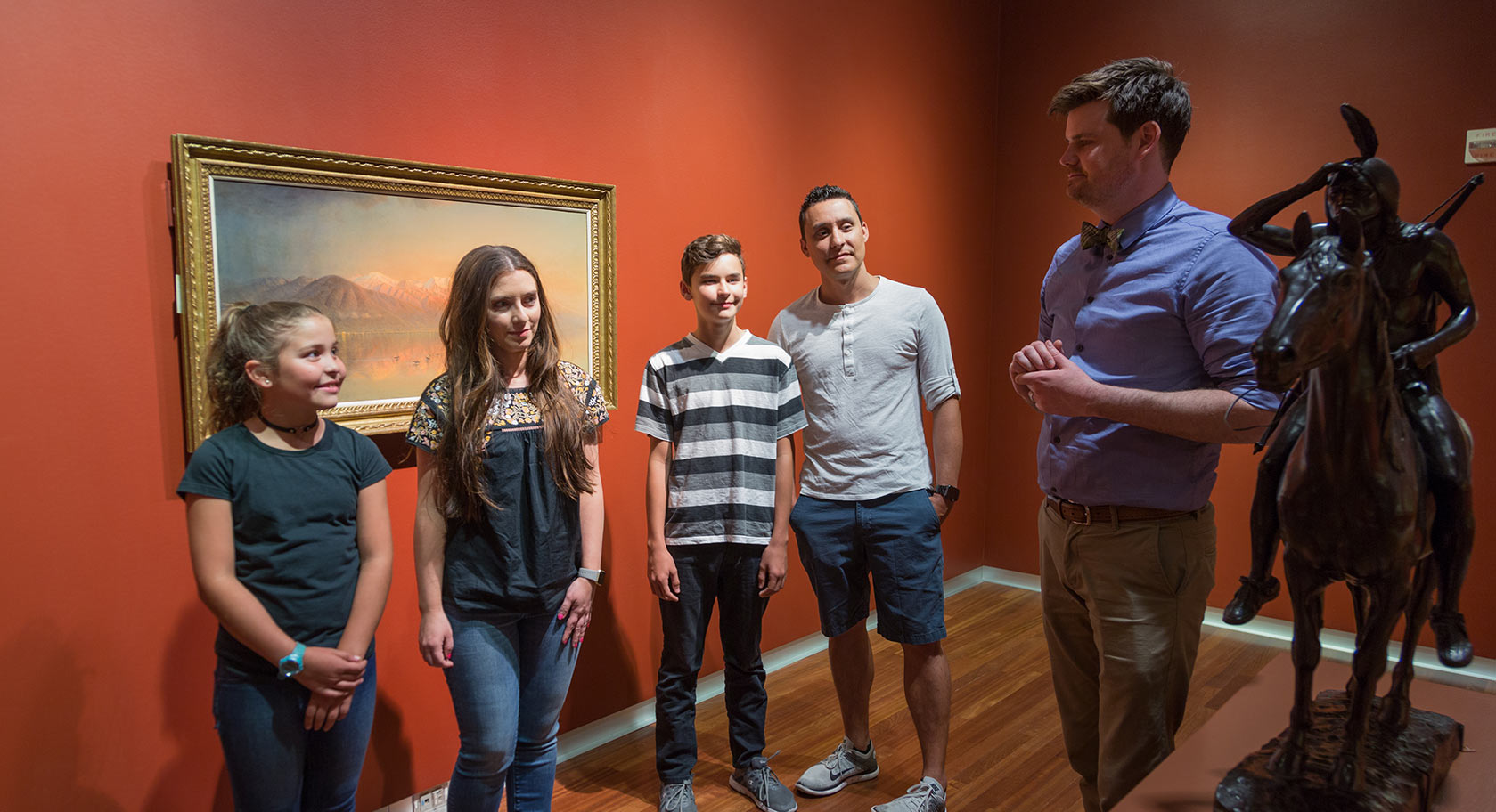 A teacher and a group of students have a discussion in the gallery.