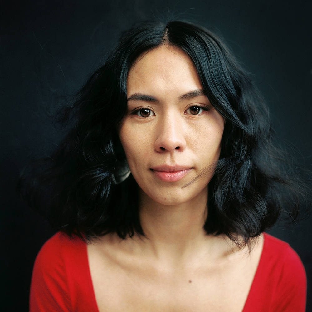 Denae Shanidiin, an Indigenous-Korean woman with black hair in a red shirt.