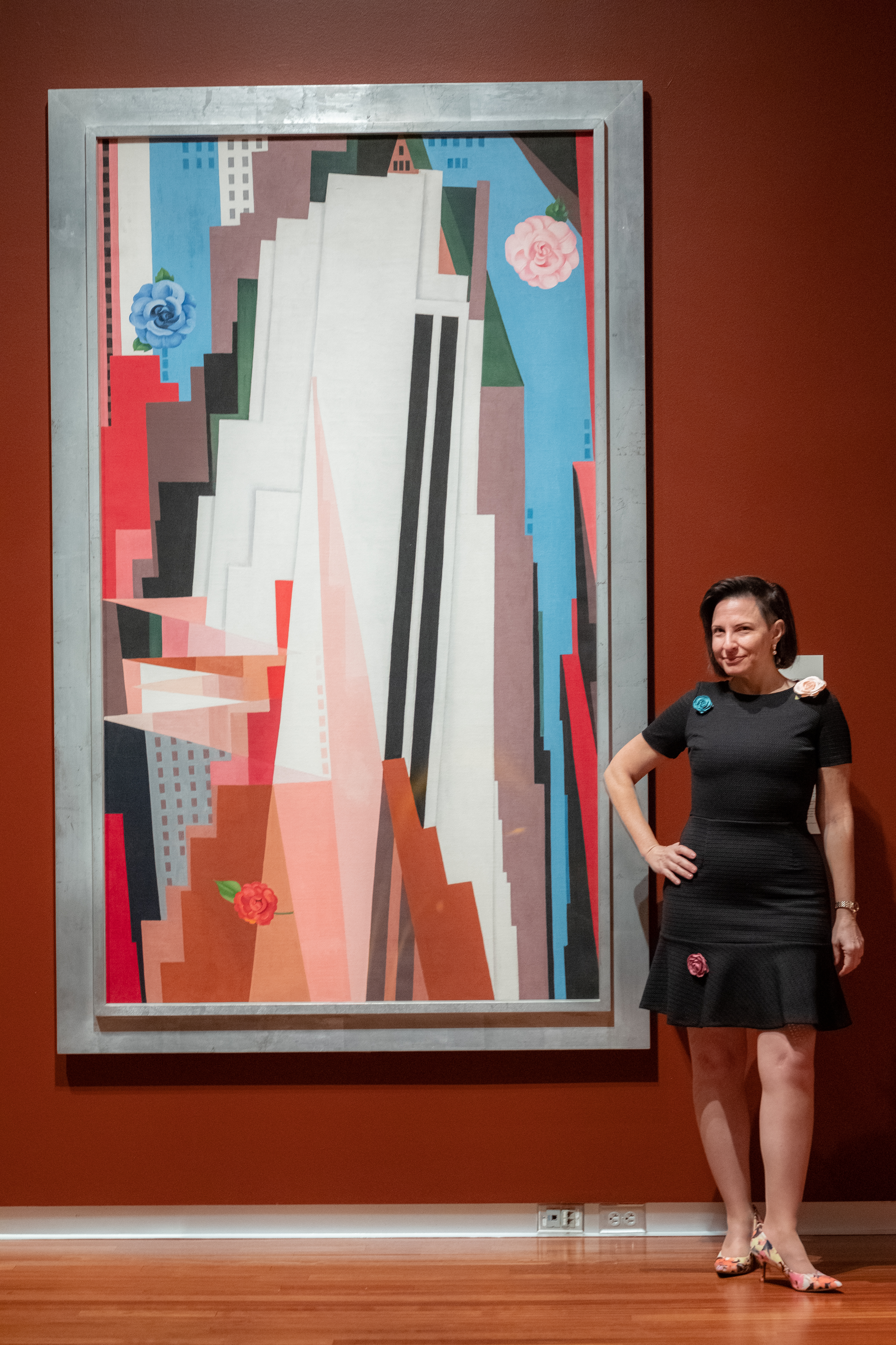Curator Alana Wolf poses beside Georgia O'Keefe's Manhattan, on loan from the Smithsonian American Art Museum