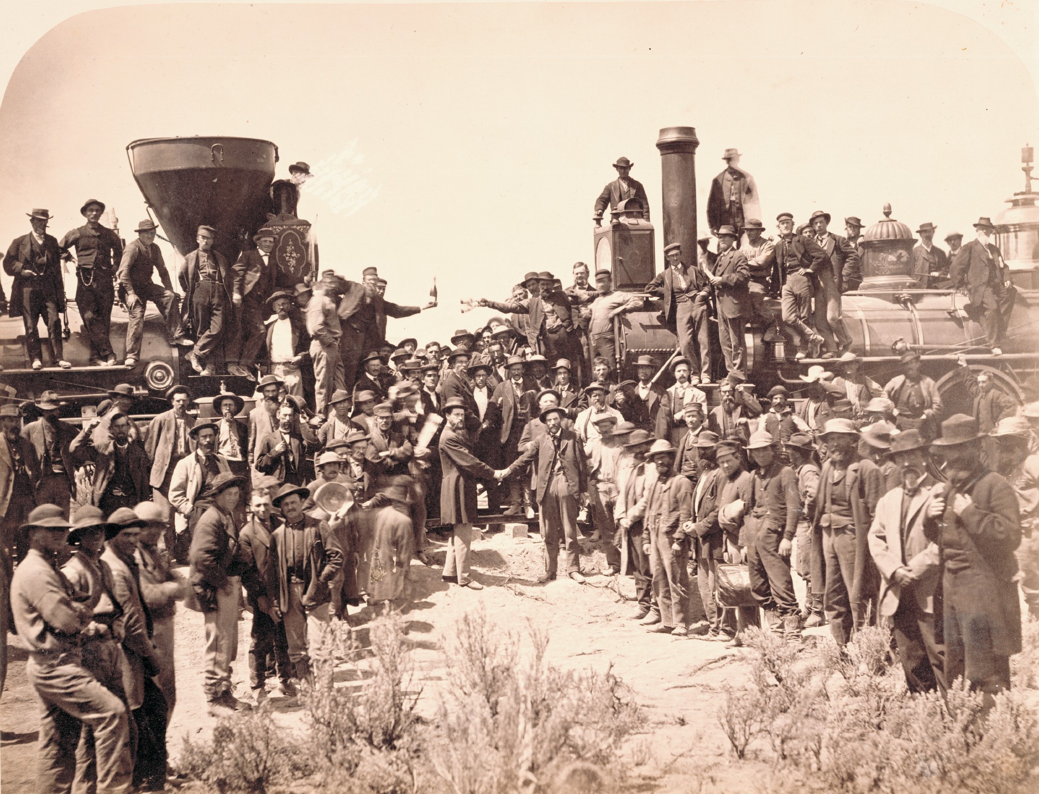 Andrew J. Russell (American, 1830–1902), East and West Shaking Hands at Laying Last Rail, 1869, albumen print, Courtesy Union Pacific Railroad Museum. The ceremony spotlighted Union Pacific locomotive No. 119 meeting Central Pacific locomotive Jupiter. From left, shaking hands, are Samuel S. Montague, chief engineer of the Central Pacific Railroad, and General Grenville M. Dodge, chief engineer of the Union Pacific Railroad.