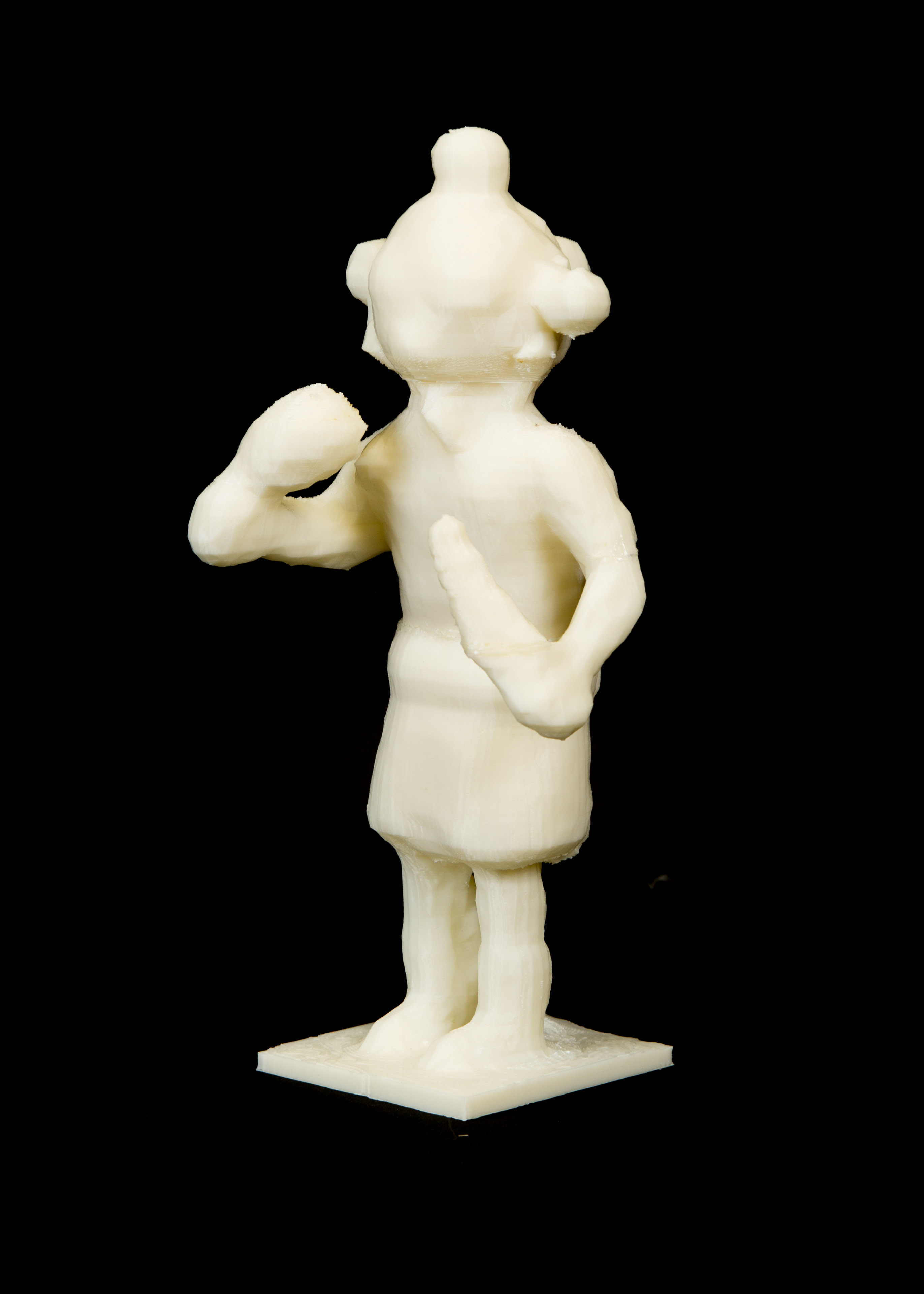 A white plastic figurine of a mudhead clown. Four round bulbs are visible on the top, sides, and back of its head.