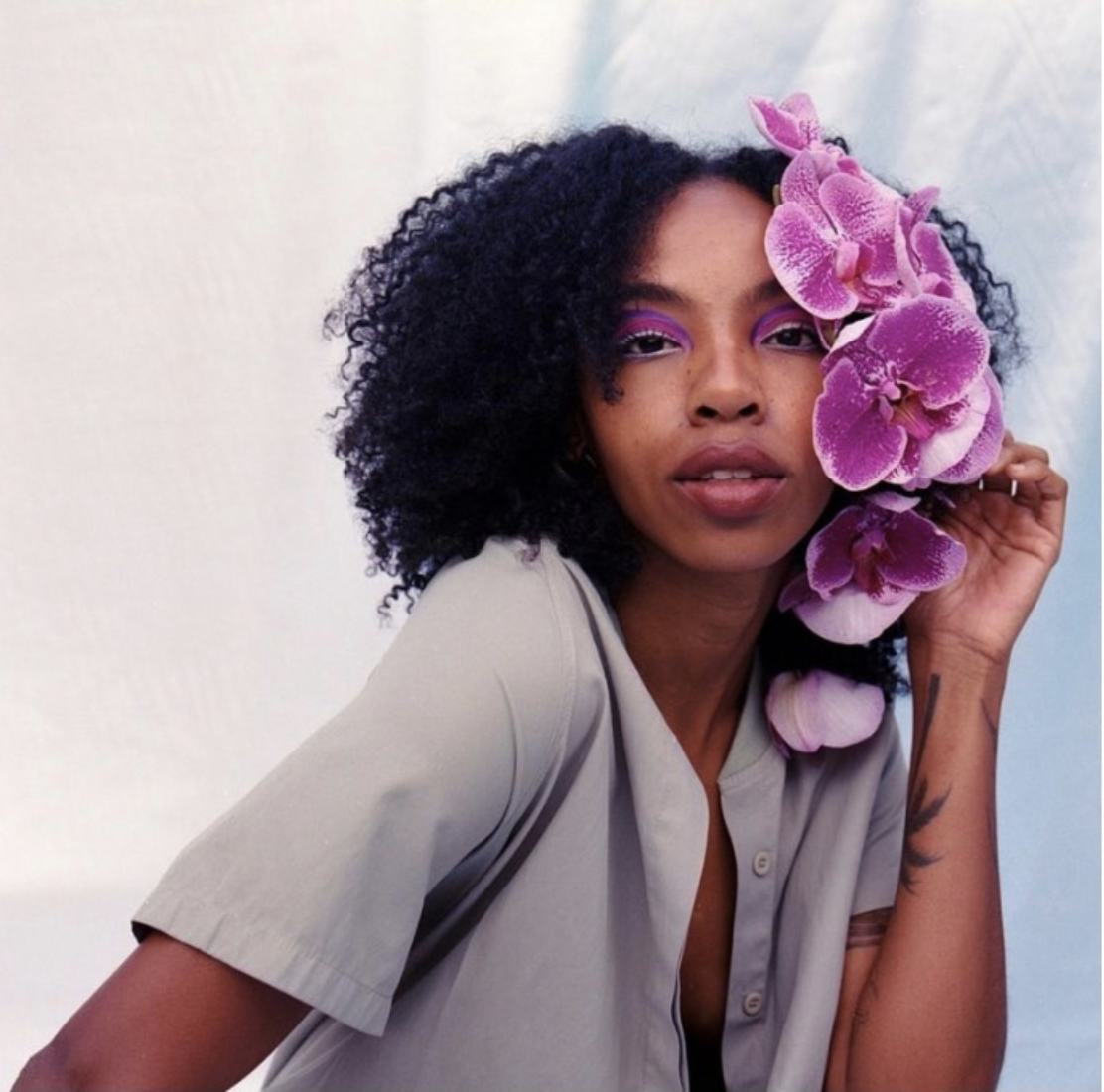 Shalandrea Houchen, a young Black woman with a mauve shirt and purple flowers alongside her face
