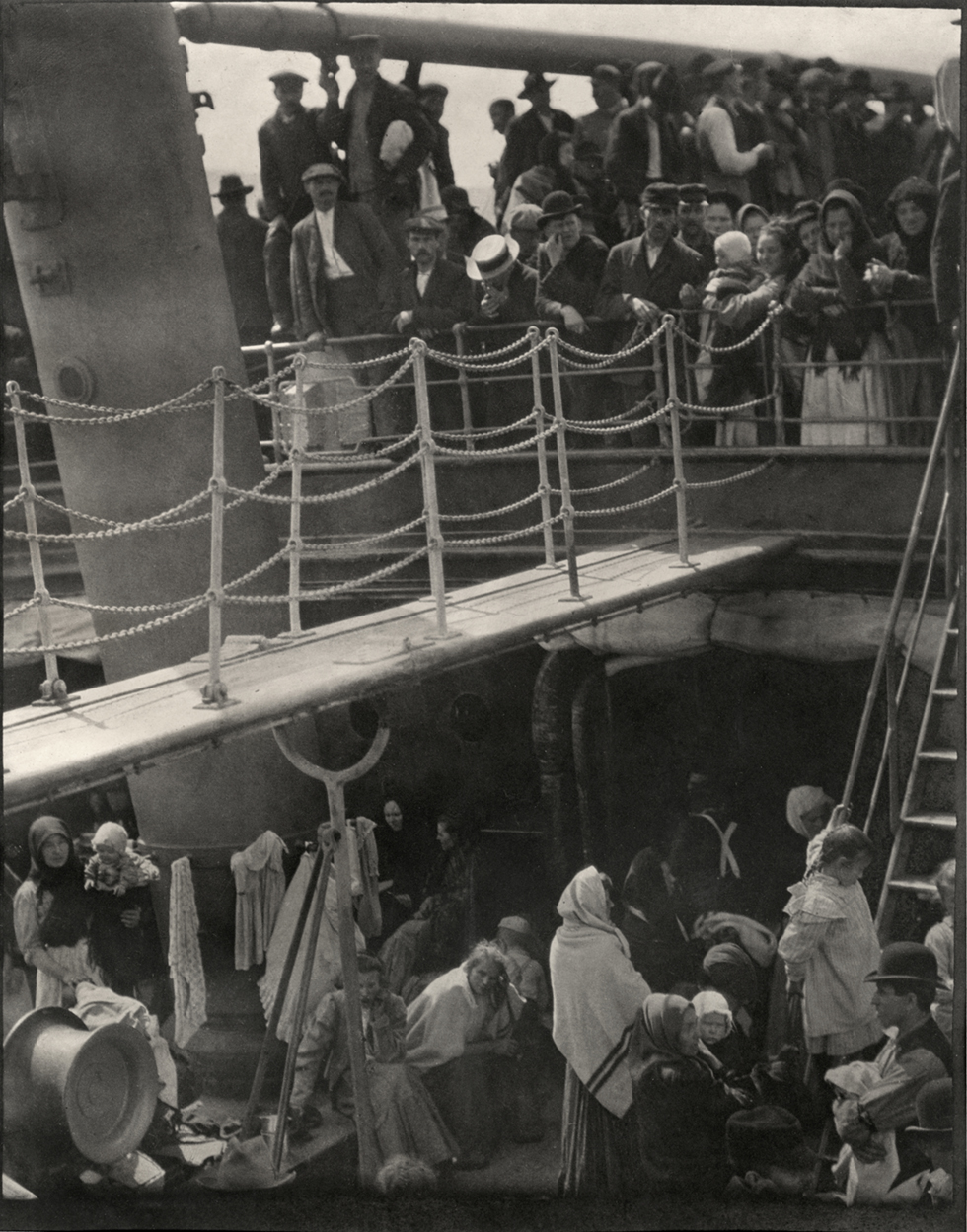 A black and white photograph of a crowded ship taken from above.