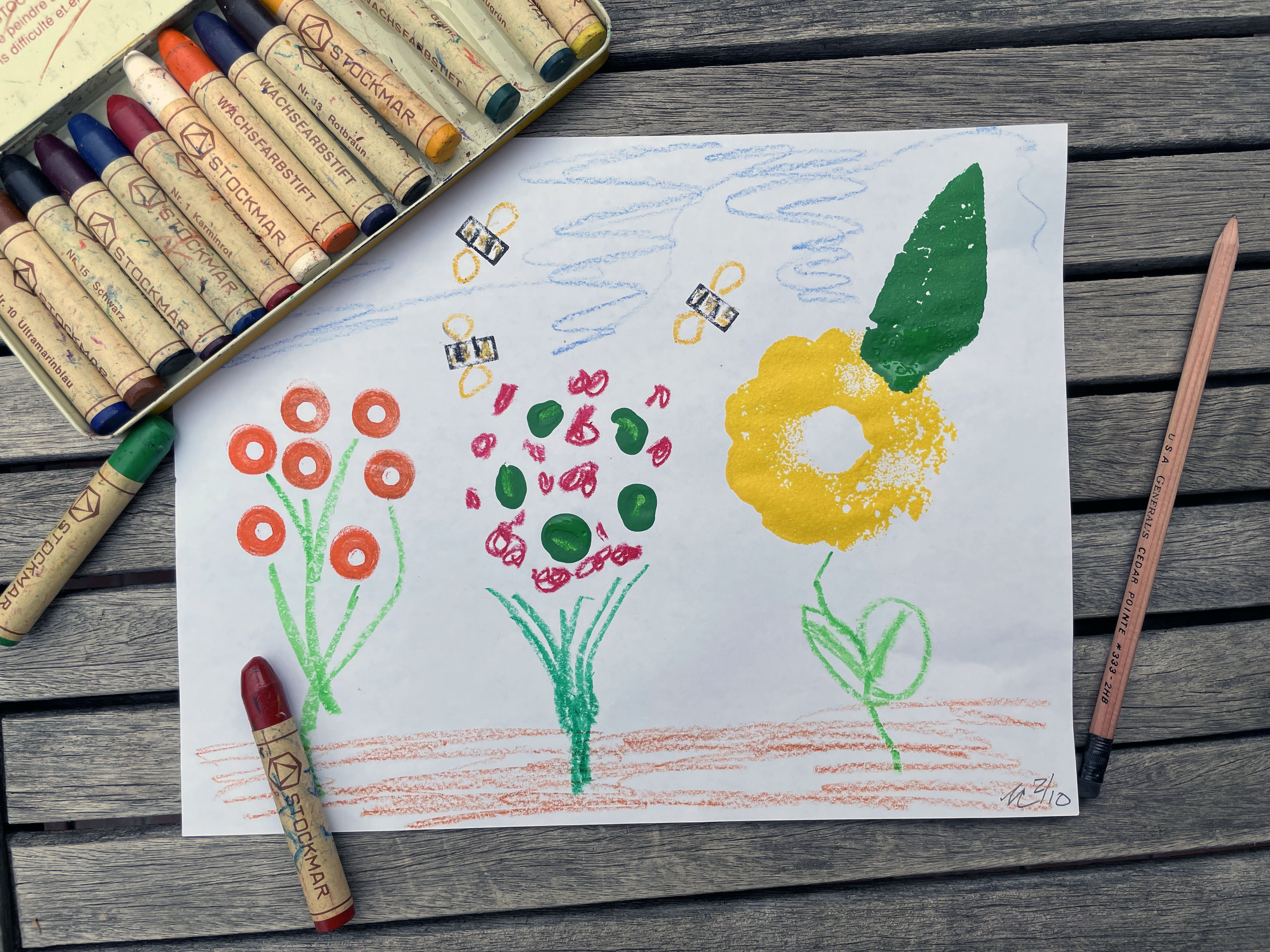 homemade print of flowers with a box of pastels sitting on a table 