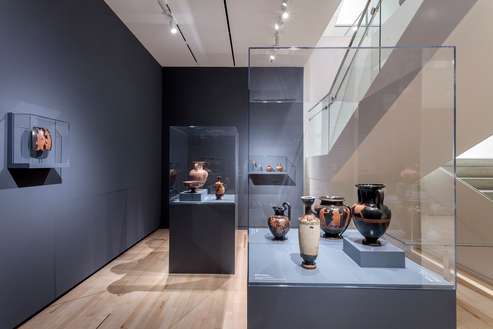 A photo of a small gallery with vessels in a glass case.