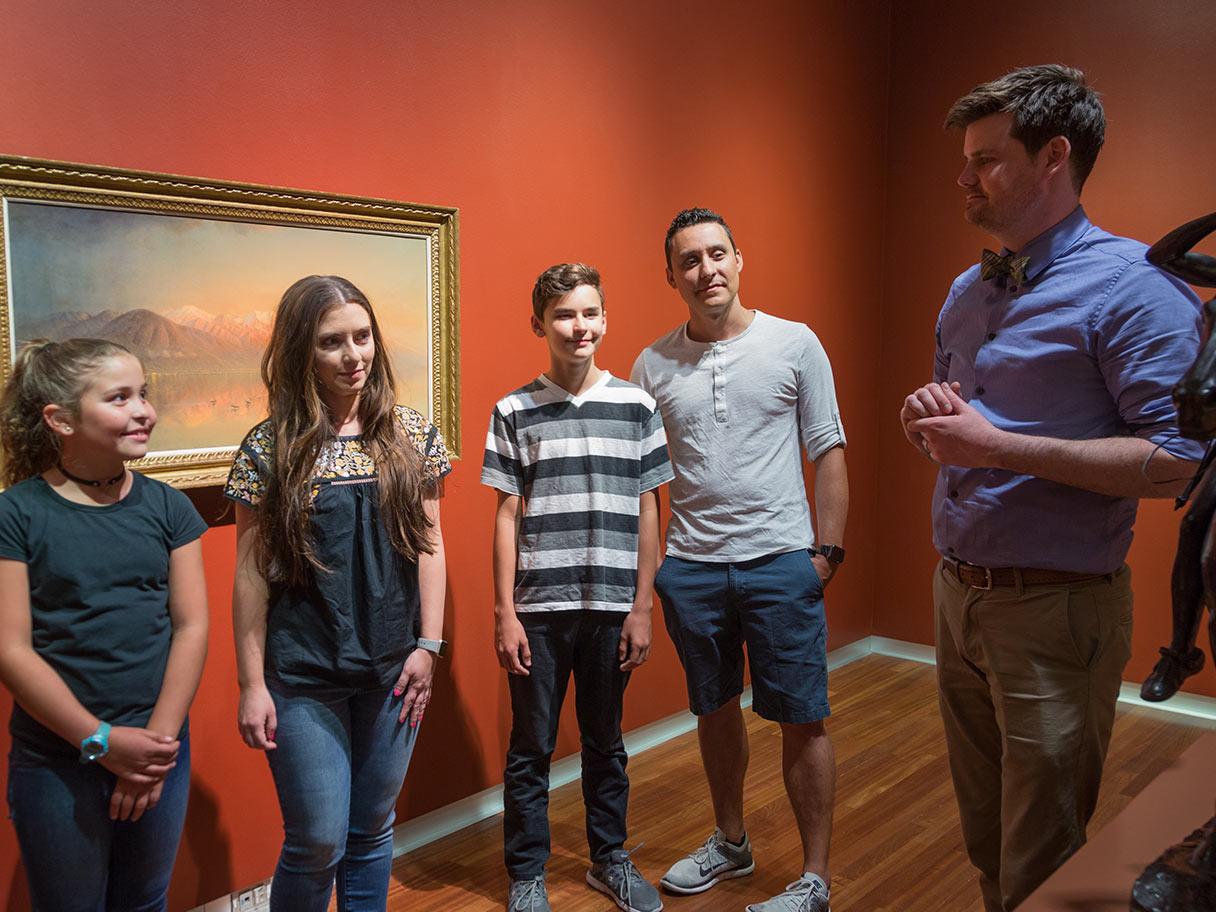 A teacher and a group of students have a discussion in the gallery. A teacher and a group of students have a discussion in the gallery.