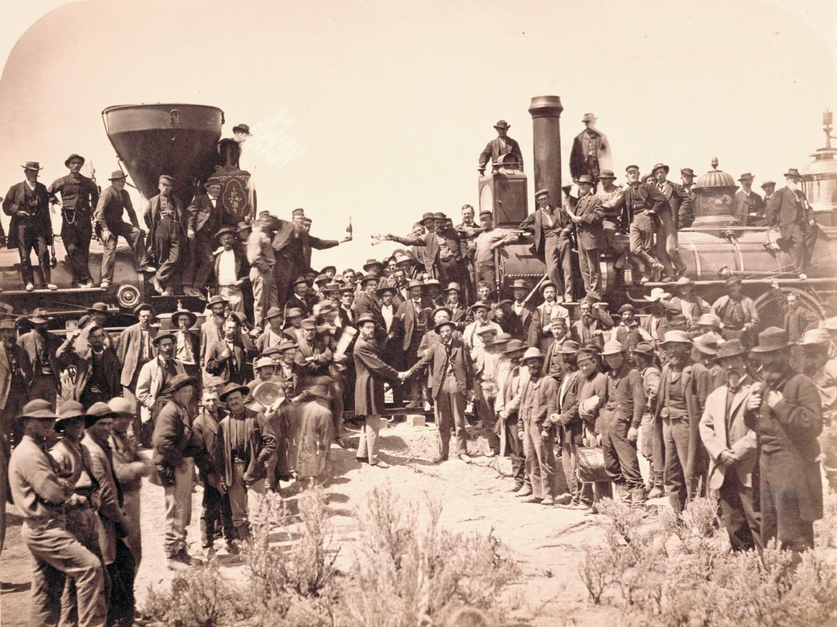 Andrew J. Russell (American, 1830­1902), East and West Shaking Hands at Laying Last Rail, 1869, albumen print, courtesy Union Pacific Railroad Museum. The ceremony spotlighted Union Pacific locomotive No. 119 meeting Central Pacific locomotive Jupiter. From left, shaking hands, are Samuel S. Montague, chief engineer of the Central Pacific Railroad, and General Grenville M. Dodge, chief engineer of the Union Pacific Railroad. 