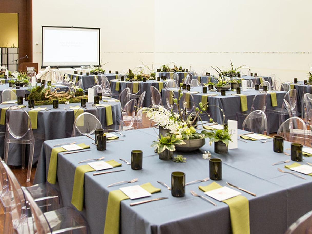 Wedding in UMFA Great Hall Modern wedding table settings lucite chairs with green and gray linens in the UMFA Great Hall