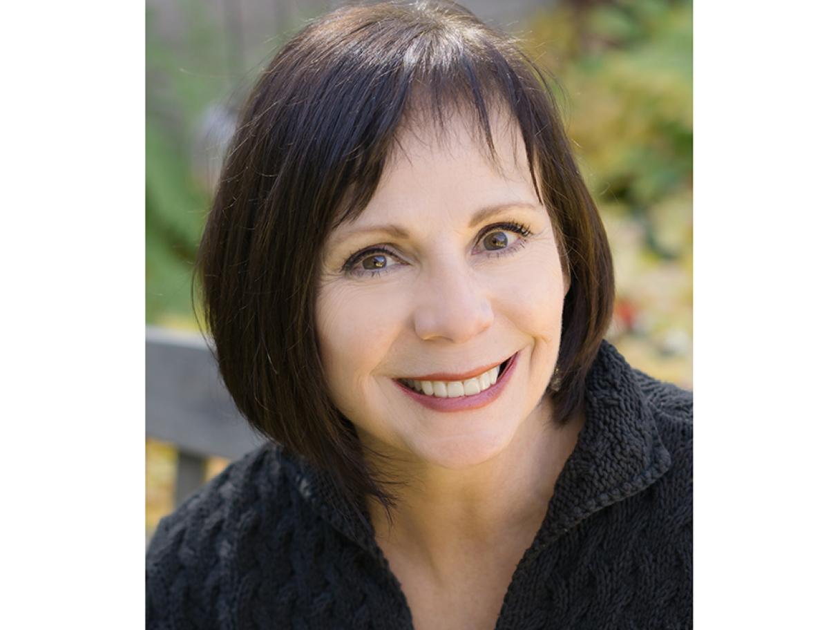 Lisa Ord headshot woman smiling she has shot dark brown bob and a black blouse