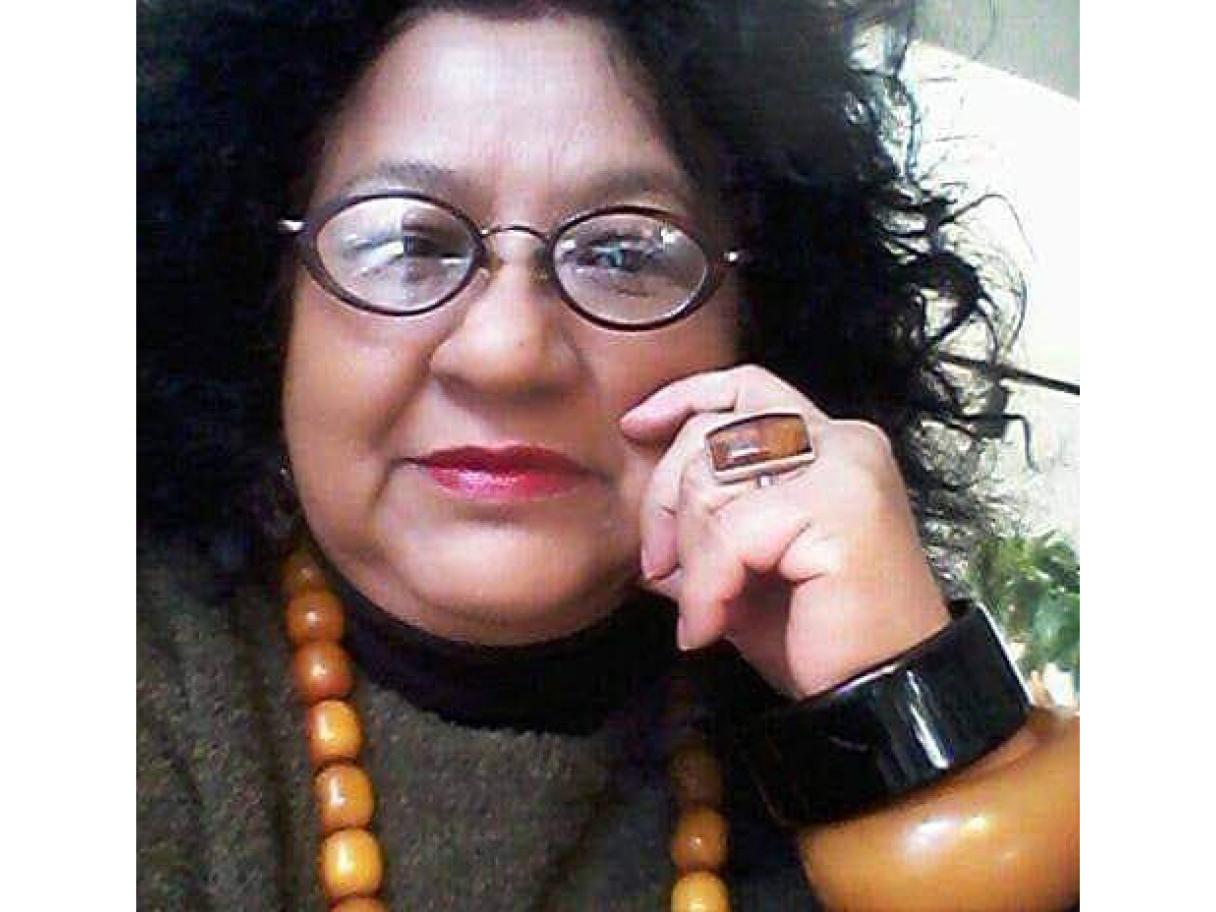 Meredith Anderson Franck Meredith Anderson Franck wearing a white shirt and large statement necklace of turquoise and silver, she has shoulder length dark curly hair