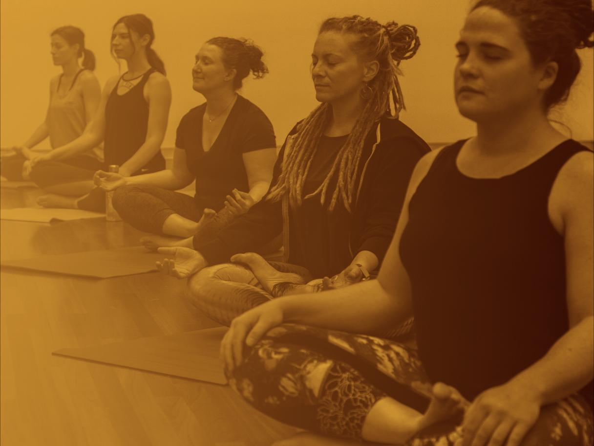 Yoga attendees meditate in Buddha pose in the Museum. 