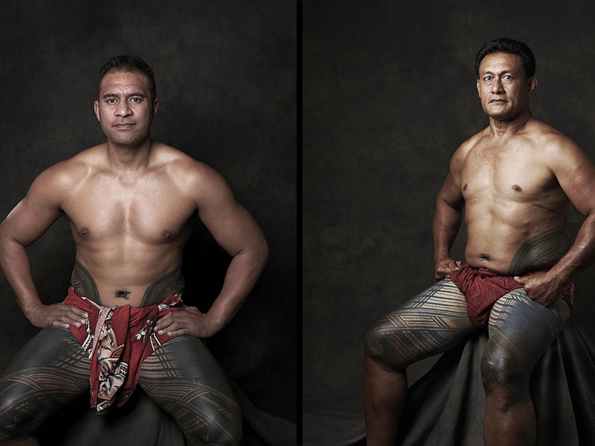 Two portraits side by side of Samoan men posing seated in a studio in front of plain gray backdrop. Both men are wearing a traditional red hued wrap around third midsection with their hands on their hips that have traditional tatau covering their legs. 