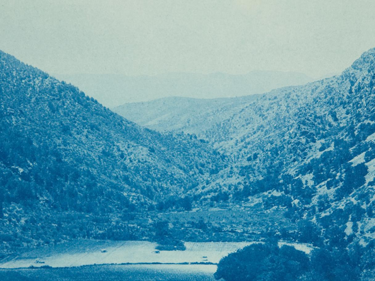 A blue photograph of a mountain valley