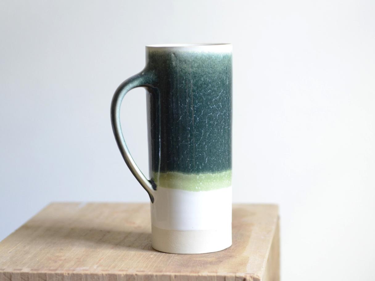 Dark green stein pottery mug with light green stripe and white bottom 