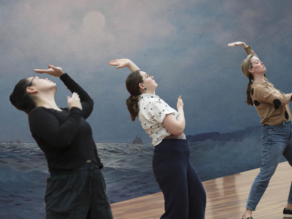 Three people are bent backwards in the same position. There's a mural of an ocean with a cloudy blue sky behind them.