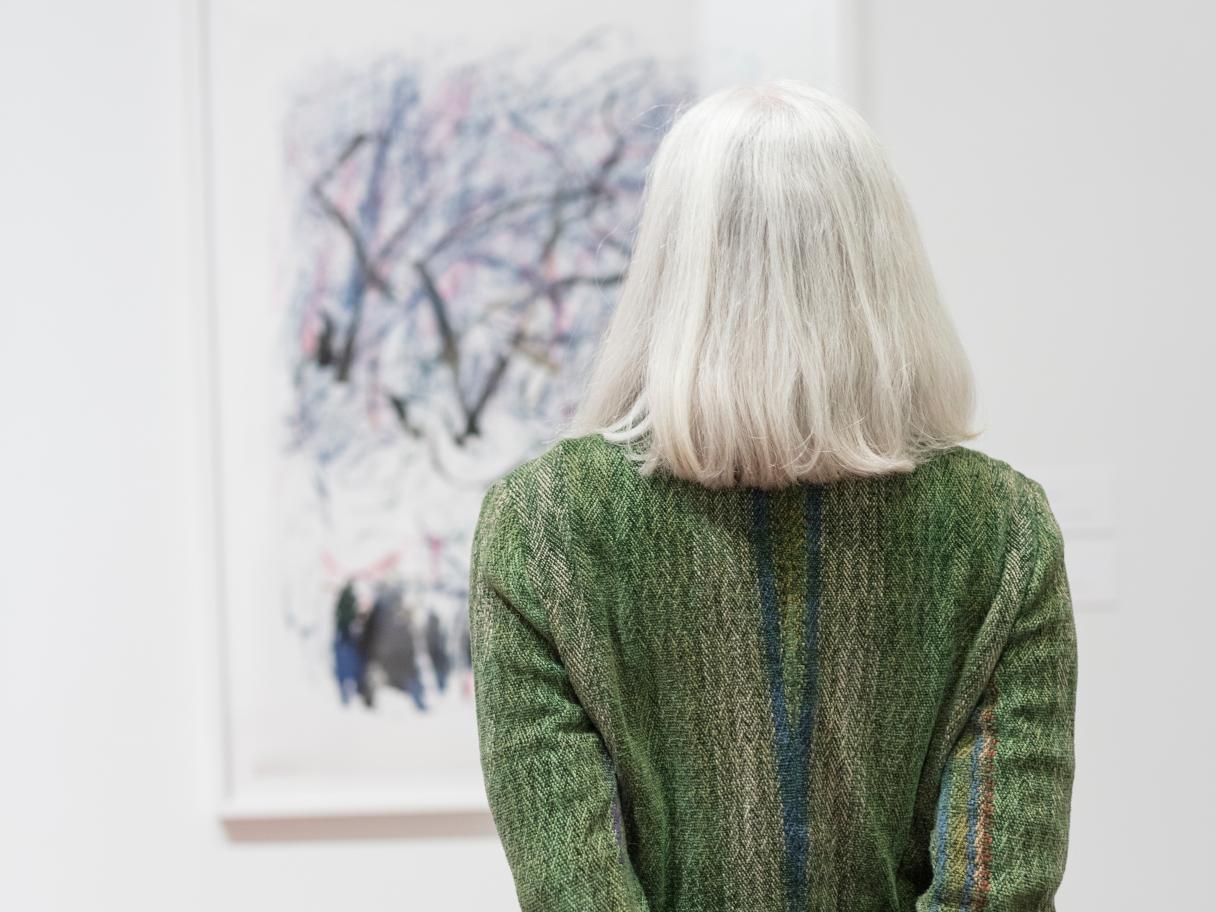 A guest facing away from the camera looking at an art piece. 