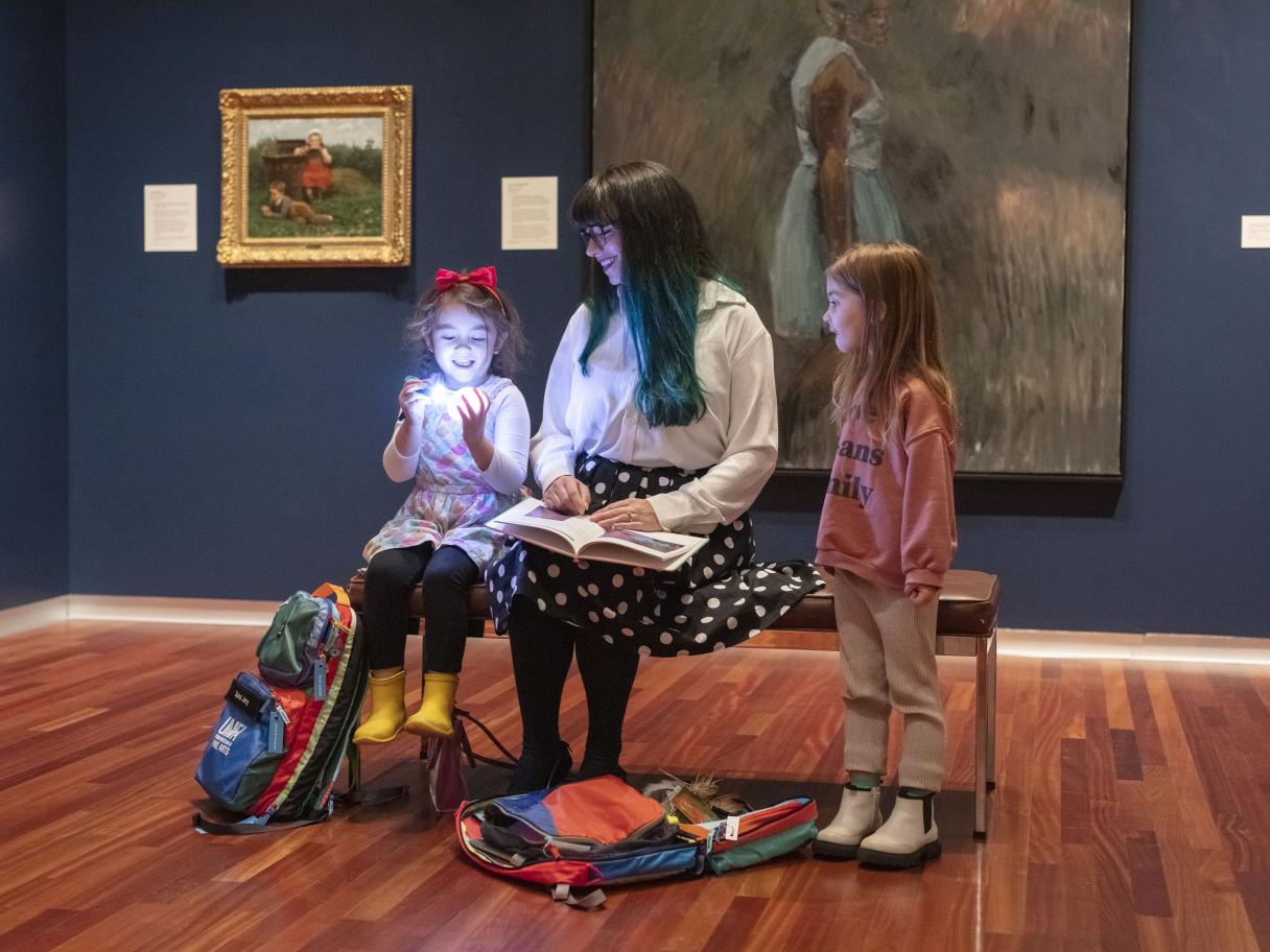 A family explores a gallery at UMFA with provided family backpacks to enhance their experience.
