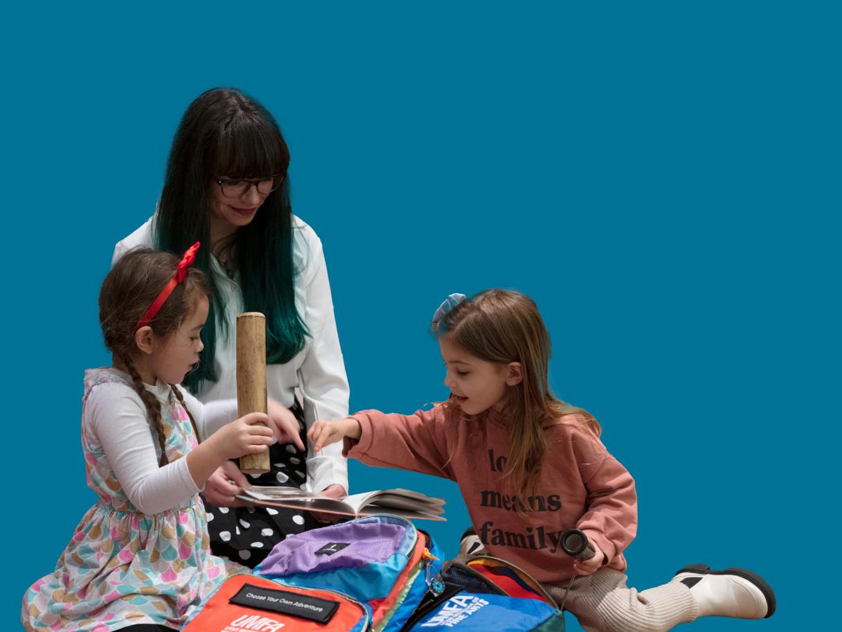 A family sits on the floor using tools in a sensory backpack.