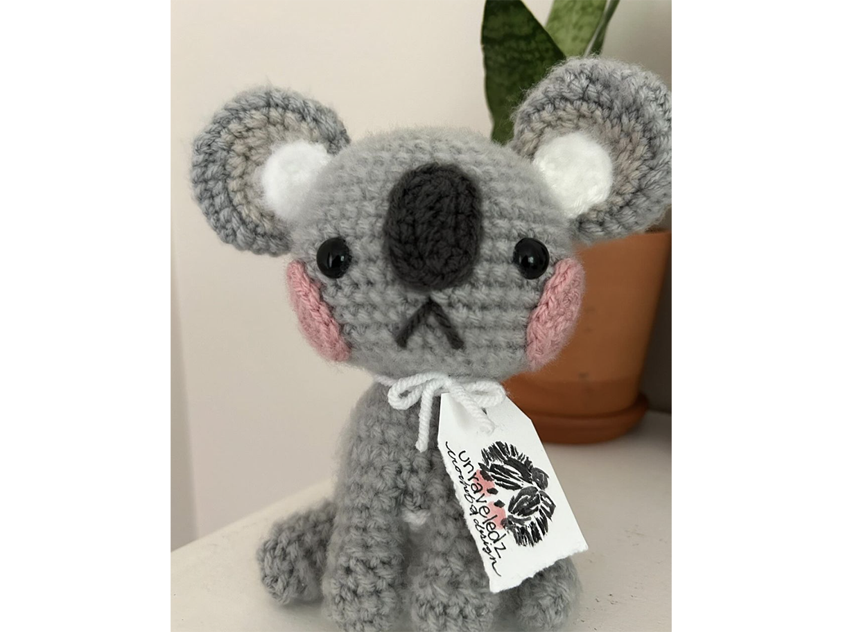 A grey crocheted, stuffed koala bear toy.