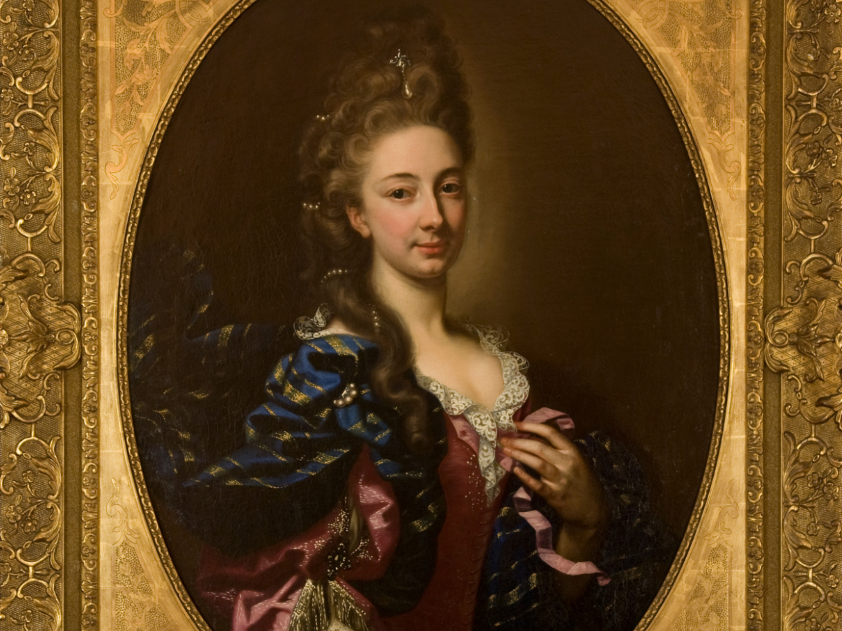 A portrait of a white woman in an gold oval frame.