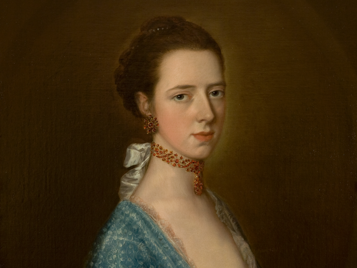 A portrait of a white woman wearing a beaded choker necklace and a blue gown.