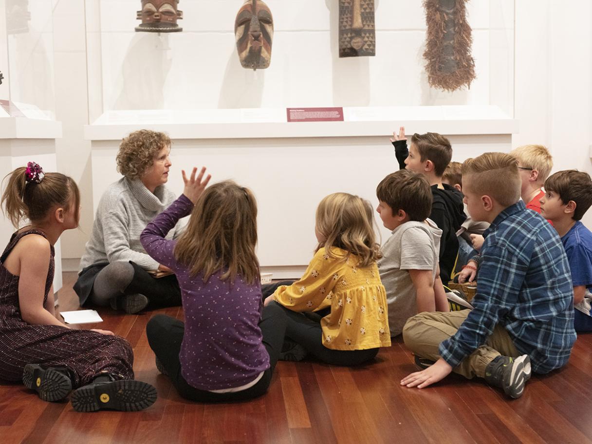 Field Trip A group of young students sit on the floor, listening to a docent.
