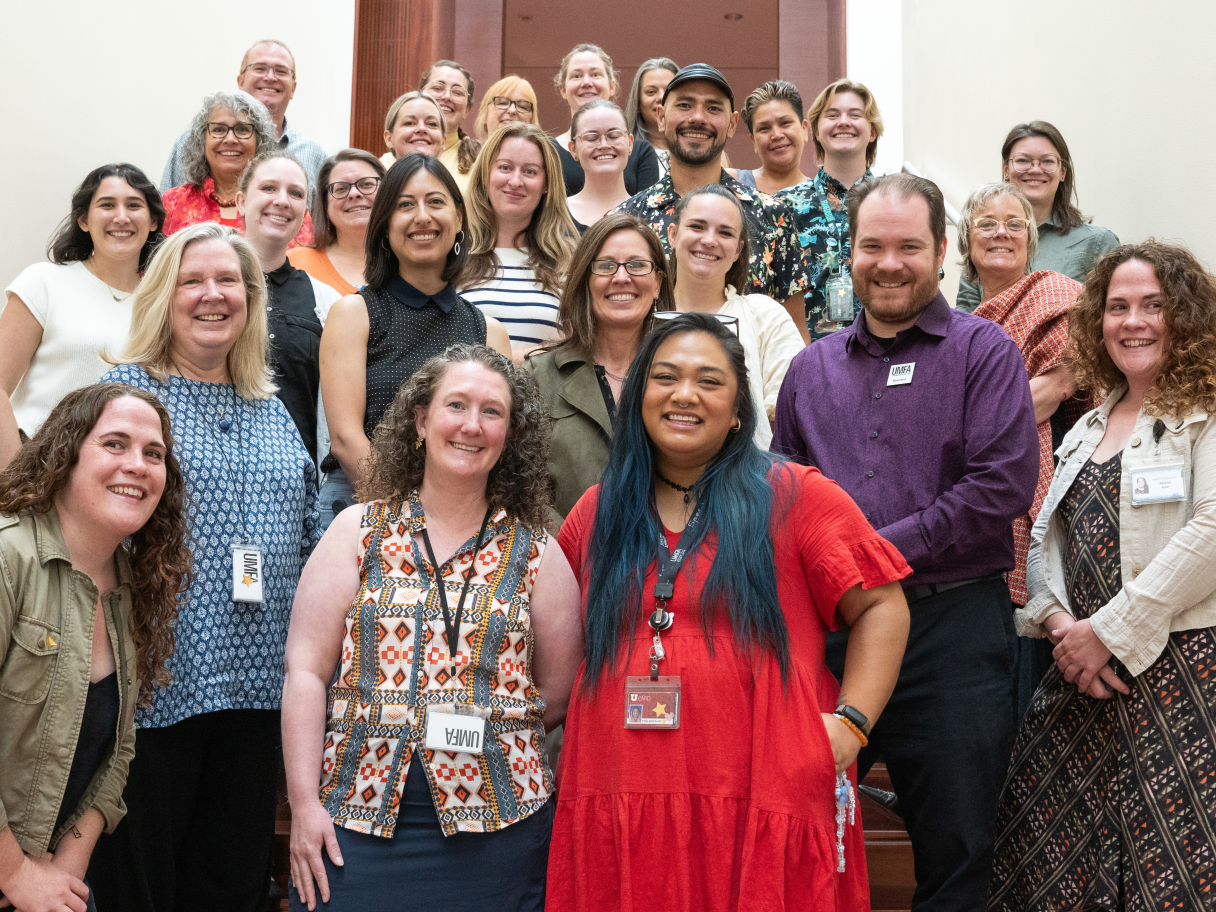 The staff of the UMFA standing on the stairs smiling.