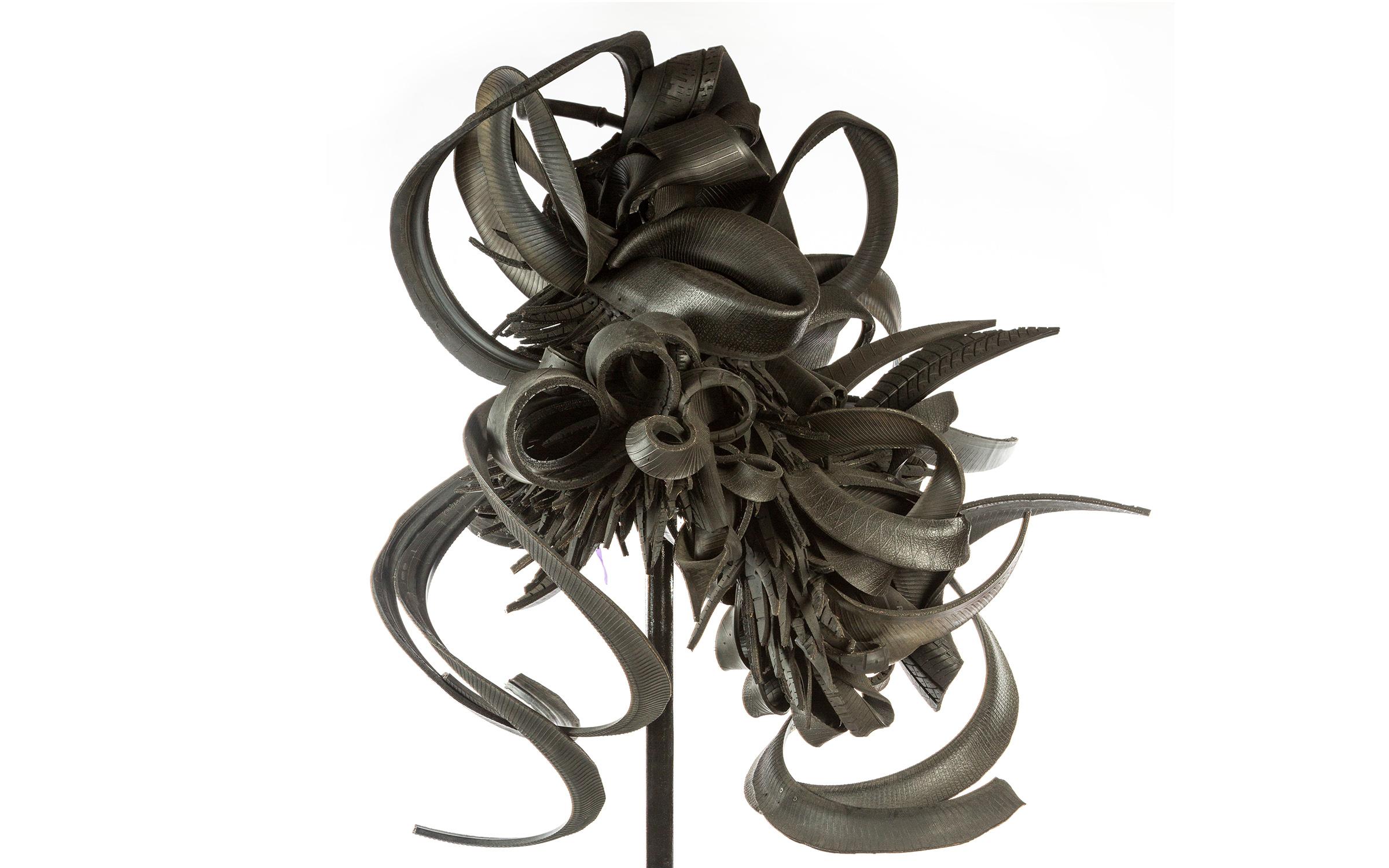 Chakaia Booker American, born 1953 Discarded Memories, 2008 Tires, wood, metal, and paint Strips of automotive tires are attached at a center mount which is in turn attached to a painted black steel pipe stand on an "X" shaped base. The strips of tires form spiral shapes that have been incorporated into the form of the sculpture.
