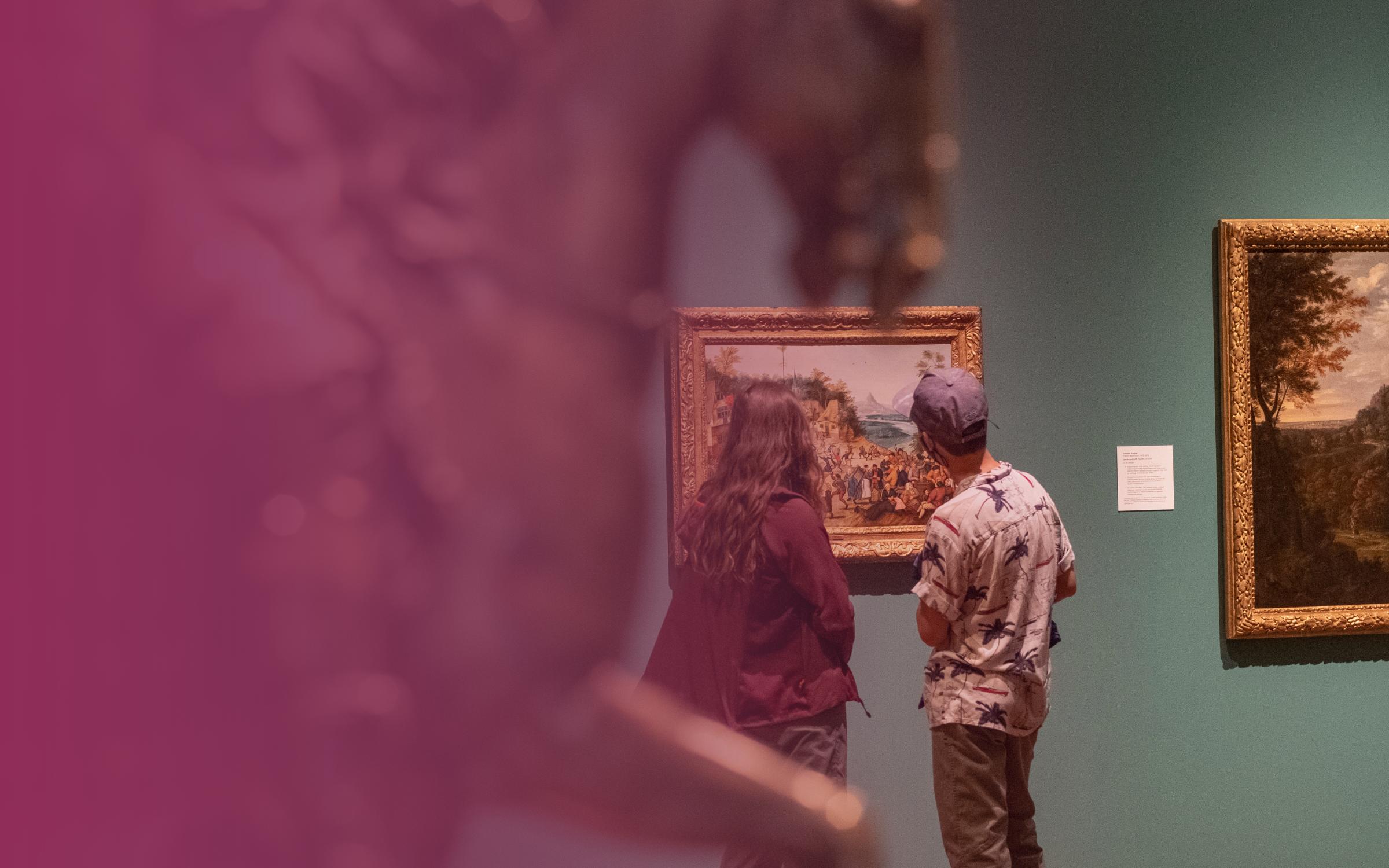 A man and woman observe art by a metal horse sculpture.