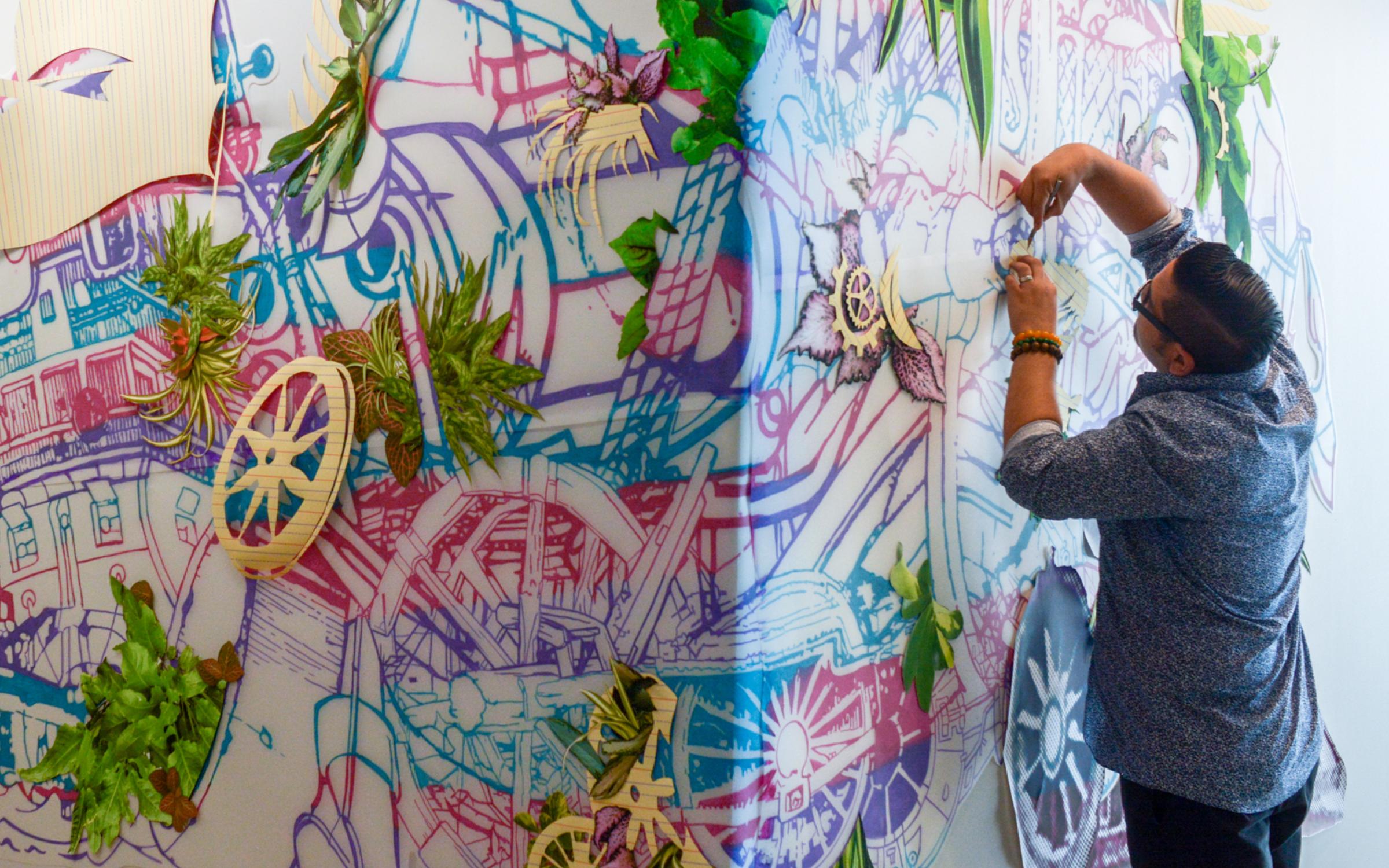 David Rios Ferreira at work David Rios Ferreira painting a large blue pink and gold wall piece