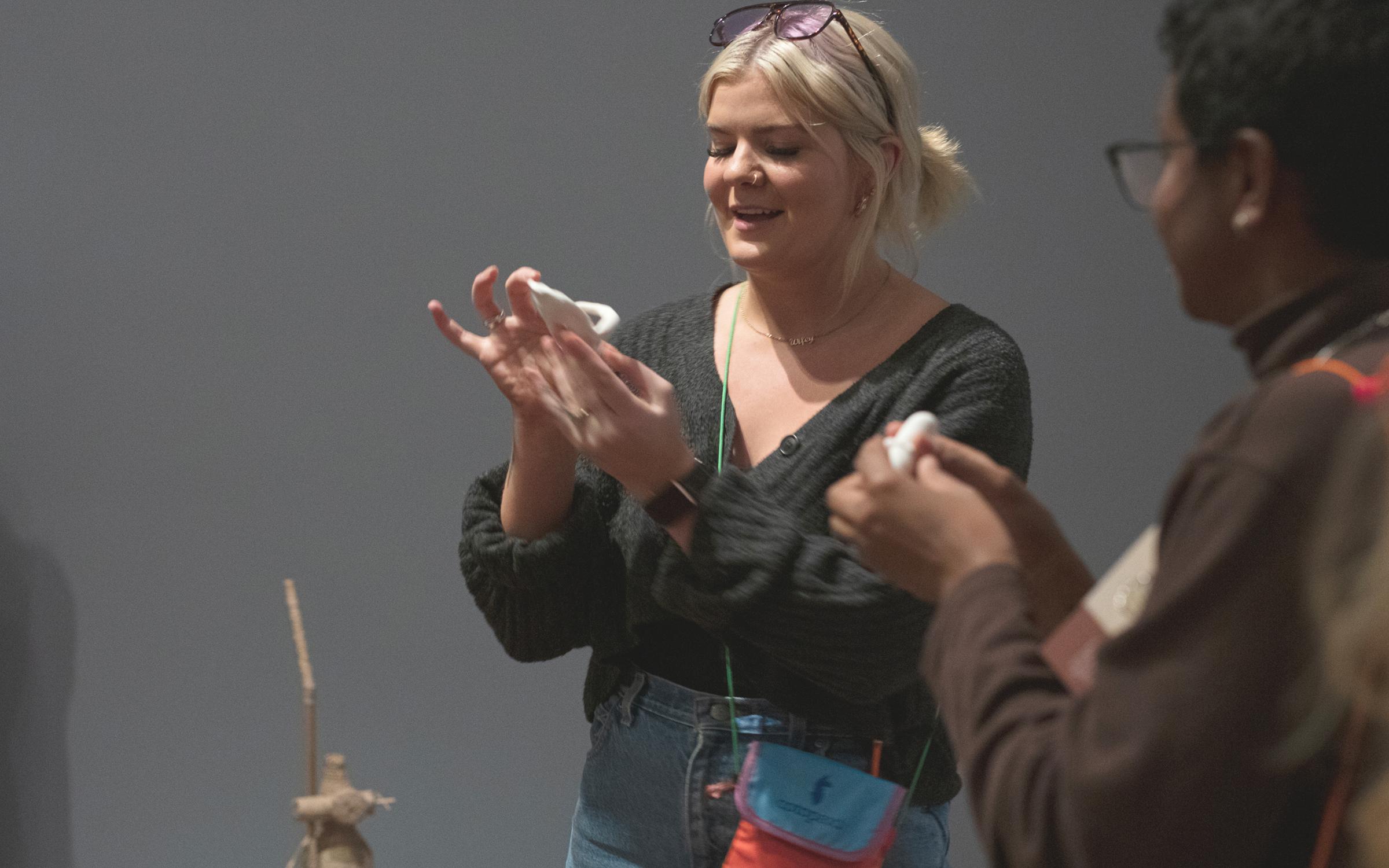 A woman holding a sculpture in her hand