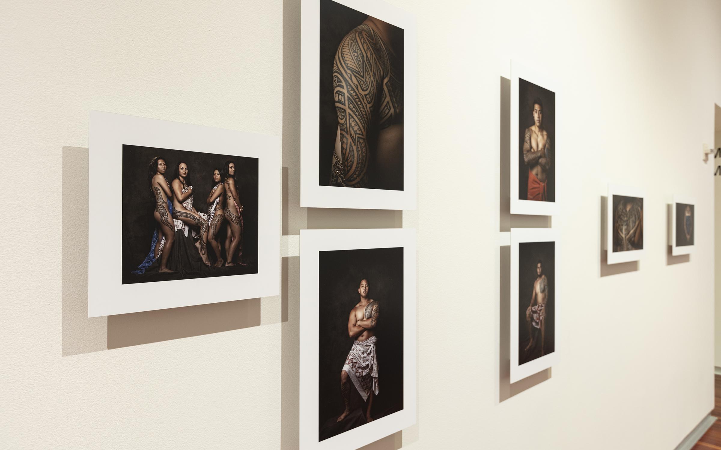 gallery wall with ten photos of people with tatau hung salon style