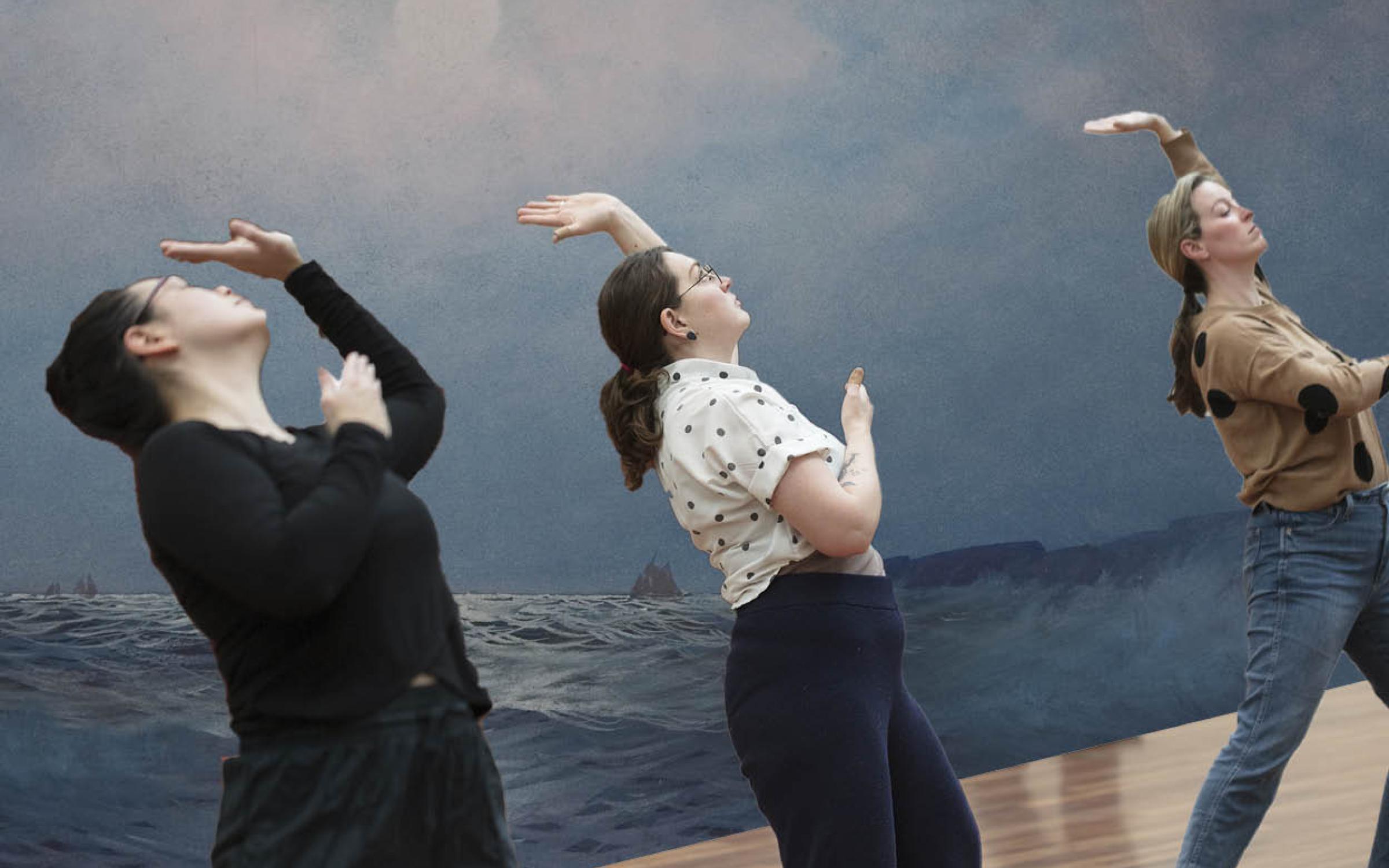 Three people are bent backwards in the same position. There's a mural of an ocean with a cloudy blue sky behind them.